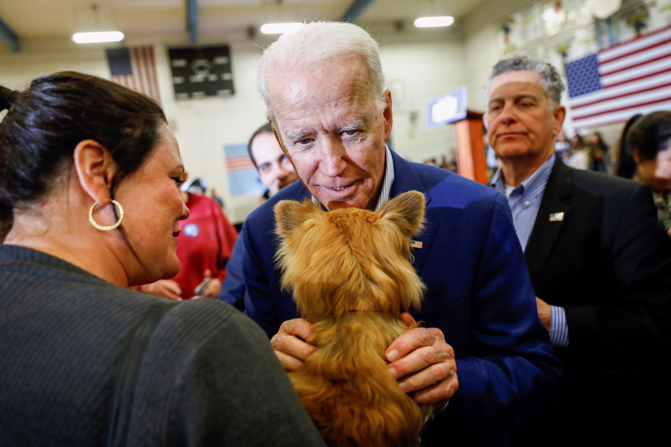 Democratic 2020 U.S. presidential candidate and former Vice President Joe Biden embraces a dog as he campaigns on the eve of the Nevada Caucus at Hyde Park Middle School in Las Vegas, Nevada Feb. 21, 2020. REUTERS/Patrick T. Fallon 