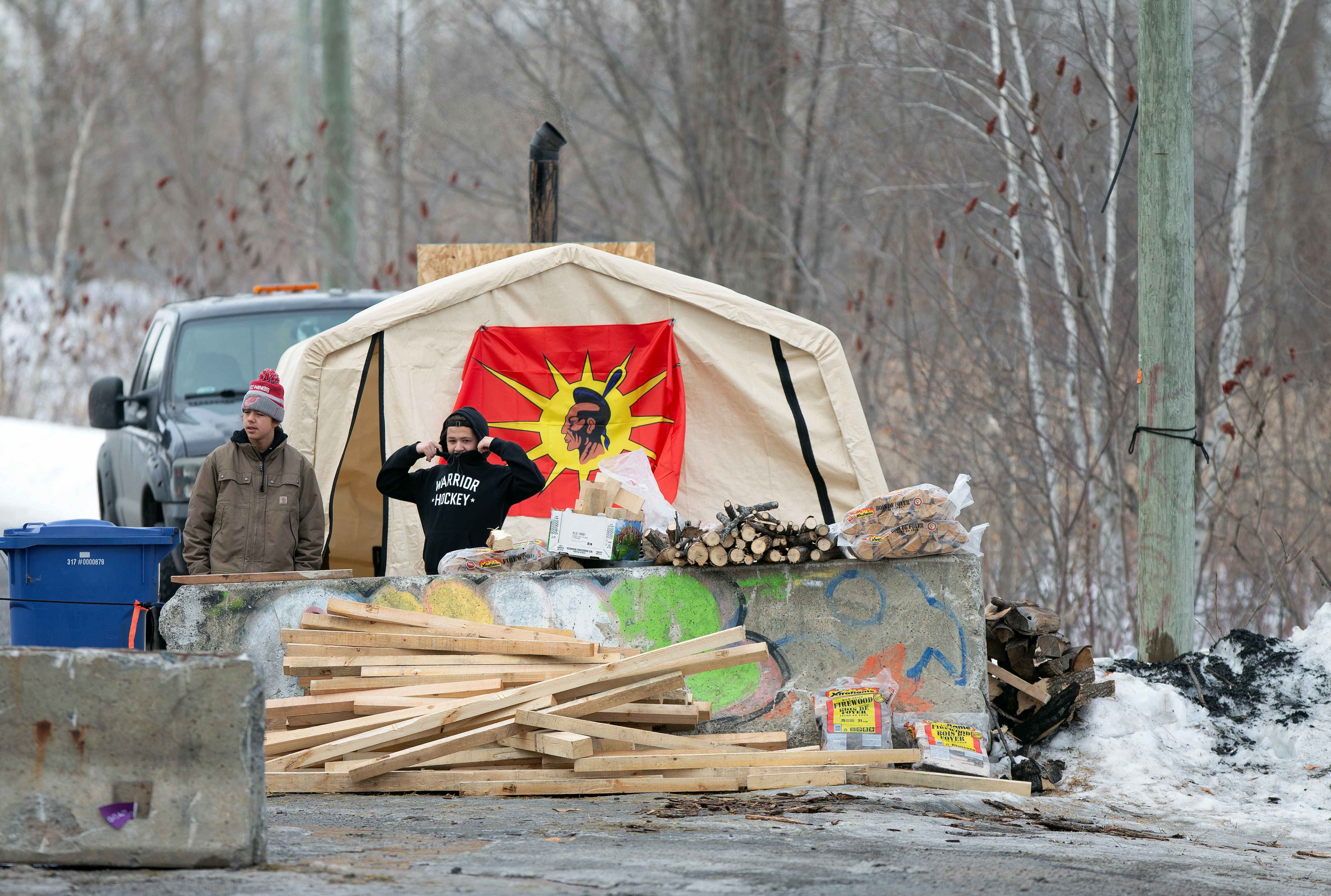 Protestors stand by a blockade closing a road in Kahnawake Mohawk Territory, south of Montreal, Quebec, Canada Feb. 25, 2020. REUTERS/Christinne Muschi