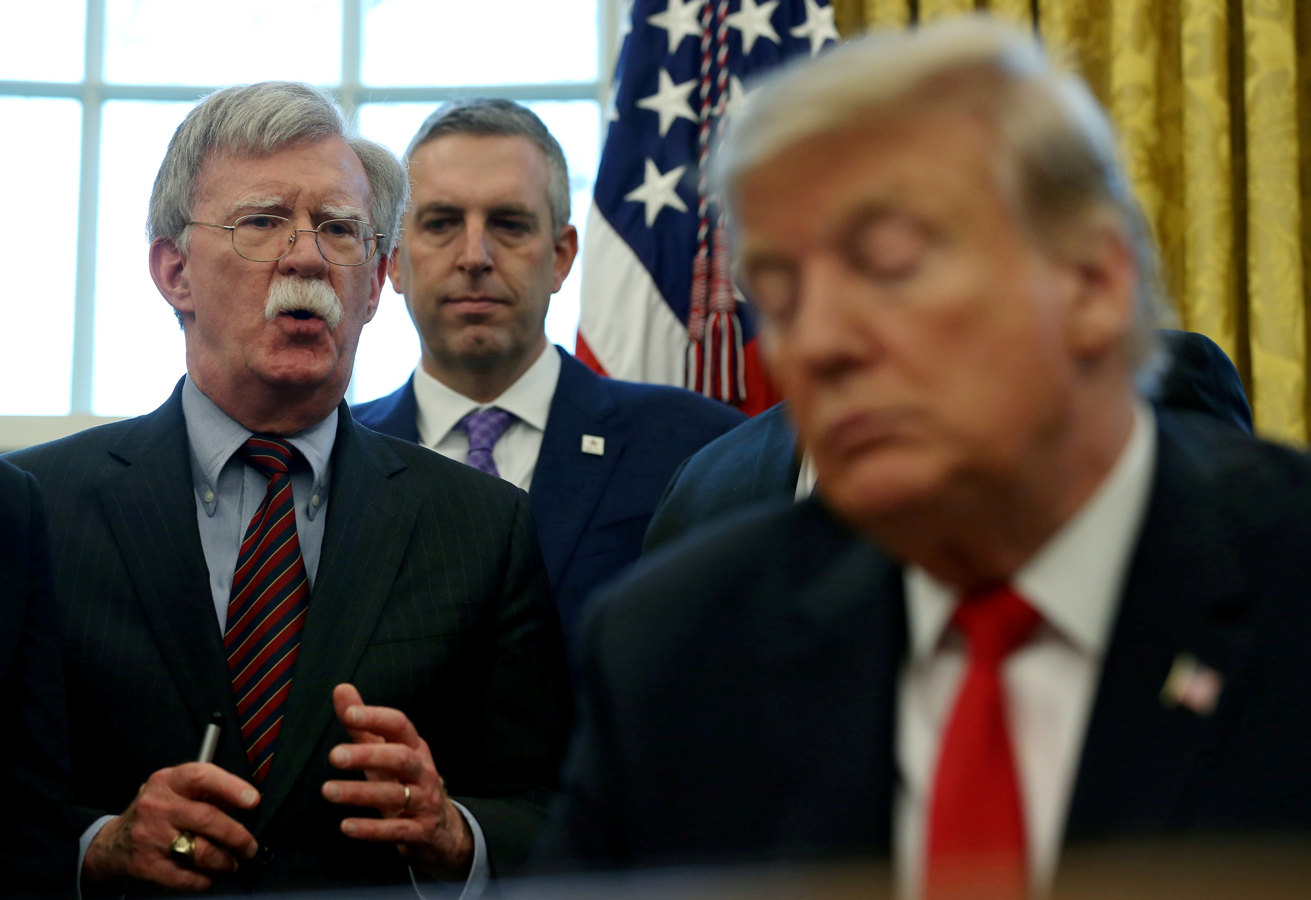 FILE PHOTO: U.S. President Donald Trump listens as his national security adviser John Bolton speaks during a presidential memorandum signing for the "Women's Global Development and Prosperity" initiative in the Oval Office at the White House in Washington, U.S., Feb. 7, 2019. REUTERS/Leah Millis/File Photo