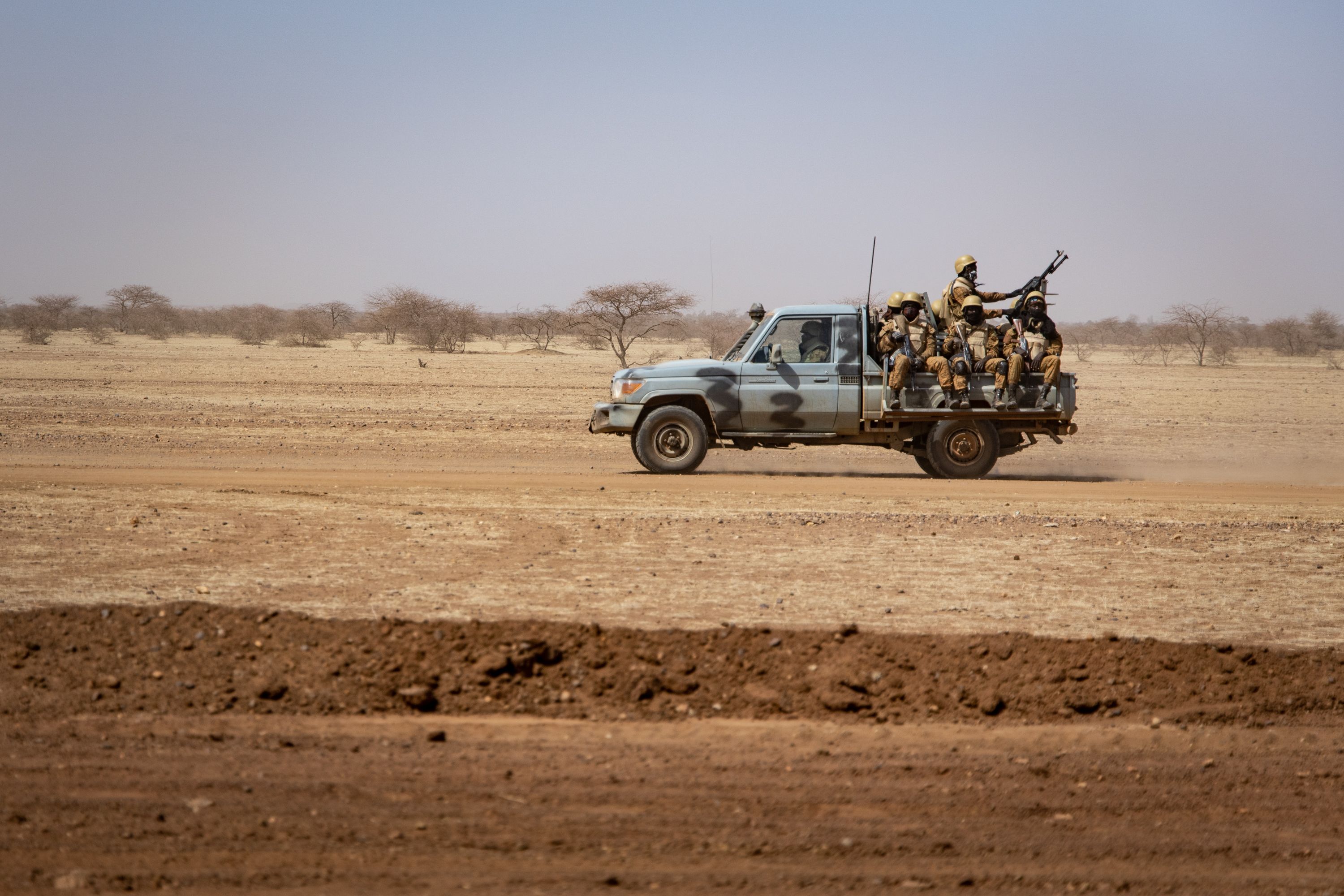 Burkina Faso soldiers patrol aboard a pick-up truck on the road from Dori to the Goudebo refugee camp, on February 3, 2020. (Photo by OLYMPIA DE MAISMONT / AFP) / The erroneous mention[s] appearing in the metadata of this photo by OLYMPIA DE MAISMONT has been modified in AFP systems in the following manner: [Burkina Faso soldiers patrol aboard a pick-up truck on the road from Dori to the Goudebo refugee camp, on February 3, 2020. ] instead of [Burkina Faso soldiers patrol aboard a pick-up truck at a camp sheltering Internally Displaced People (IDP) from Mali in Dori, on February 3, 2020. ]. Please immediately remove the erroneous mention[s] from all your online services and delete it (them) from your servers. If you have been authorized by AFP to distribute it (them) to third parties, please ensure that the same actions are carried out by them. Failure to promptly comply with these instructions will entail liability on your part for any continued or post notification usage. Therefore we thank you very much for all your attention and prompt action. We are sorry for the inconvenience this notification may cause and remain at your disposal for any further information you may require. (Photo by OLYMPIA DE MAISMONT/AFP via Getty Images)