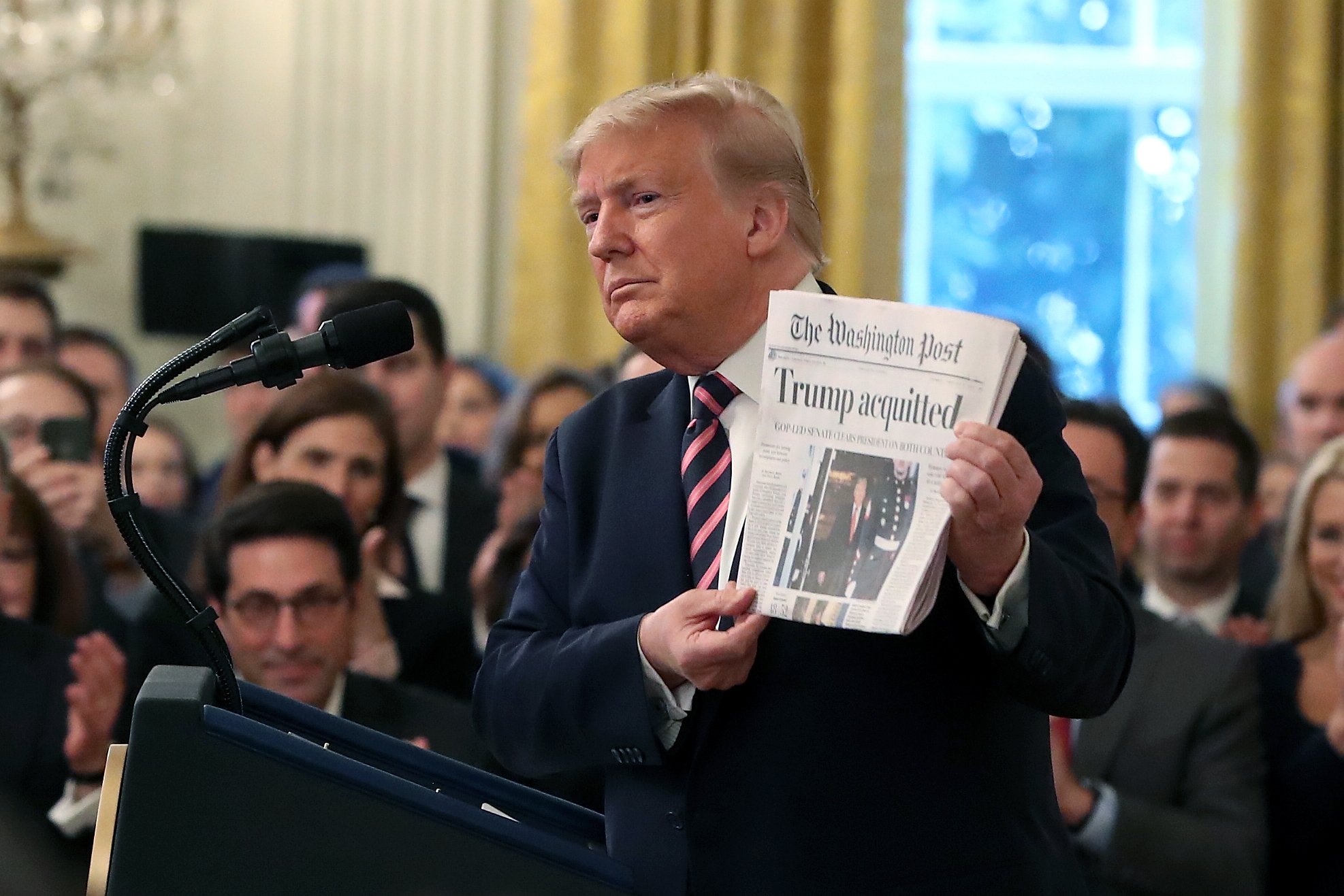 WASHINGTON, DC - FEBRUARY 06: U.S. President Donald Trump holds up a newspaper as he speaks one day after the U.S. Senate acquitted on two articles of impeachment, in the East Room of the White House February 6, 2020 in Washington, DC. After five months of congressional hearings and investigations about President Trump’s dealings with Ukraine, the U.S. Senate formally acquitted the president of charges that he abused his power and obstructed Congress. (Photo by Mark Wilson/Getty Images)