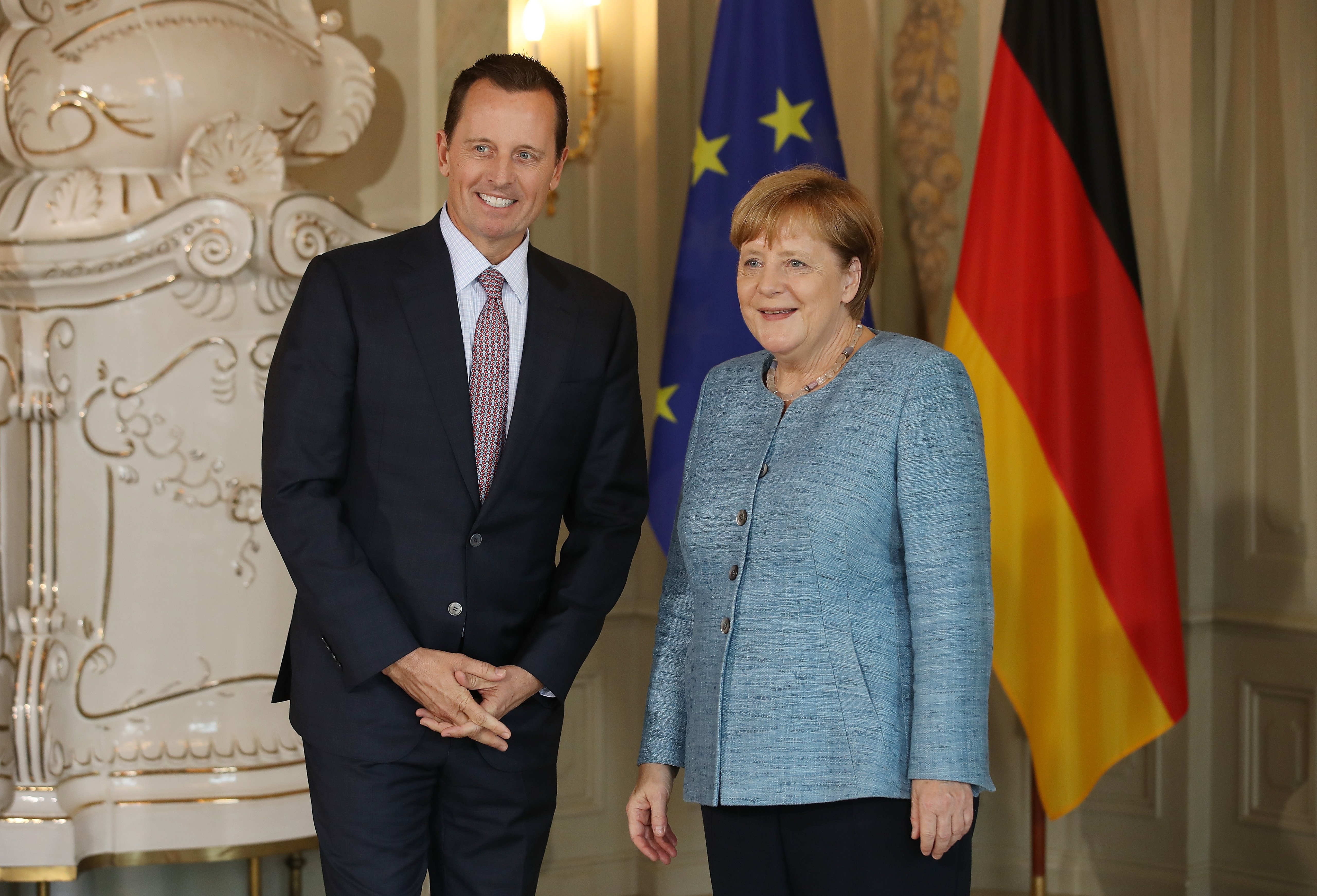 GRANSEE, GERMANY - JULY 06: U.S. Ambassador Richard Grenell poses for a photo with German Chancellor Angela Merkel upon his arrival at a reception for the diplomatic corps hosted by Merkel at Schloss Meseberg palace on July 6, 2018 near Gransee, Germany. Grenell, who was appointed ambassador by U.S. President Donald Trump, recently met with German auto executives to propose a cancelleation of tariffs on cars by both the U.S. and Germany. (Photo by Sean Gallup/Getty Images)