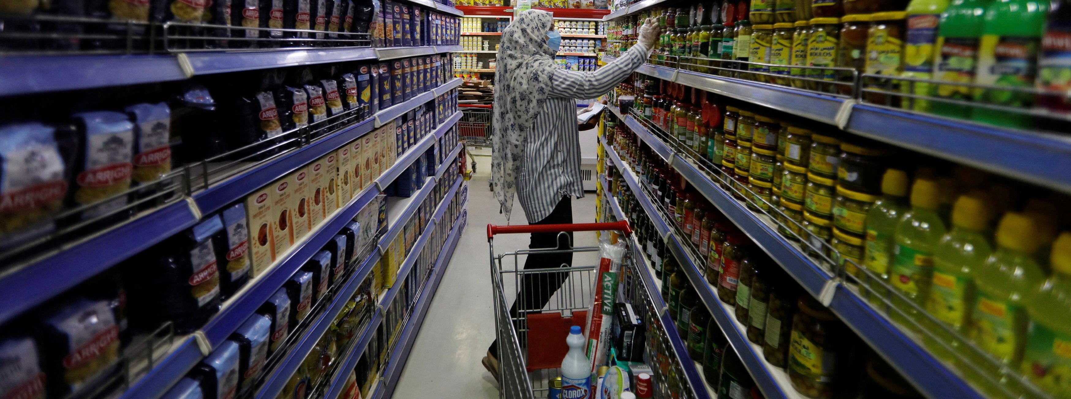A woman wears a protective face mask and gloves, as she shops at a supermarket before curfew, following the outbreak of coronavirus, in Baghdad, Iraq March 17, 2020. REUTERS/Khalid al-Mousily