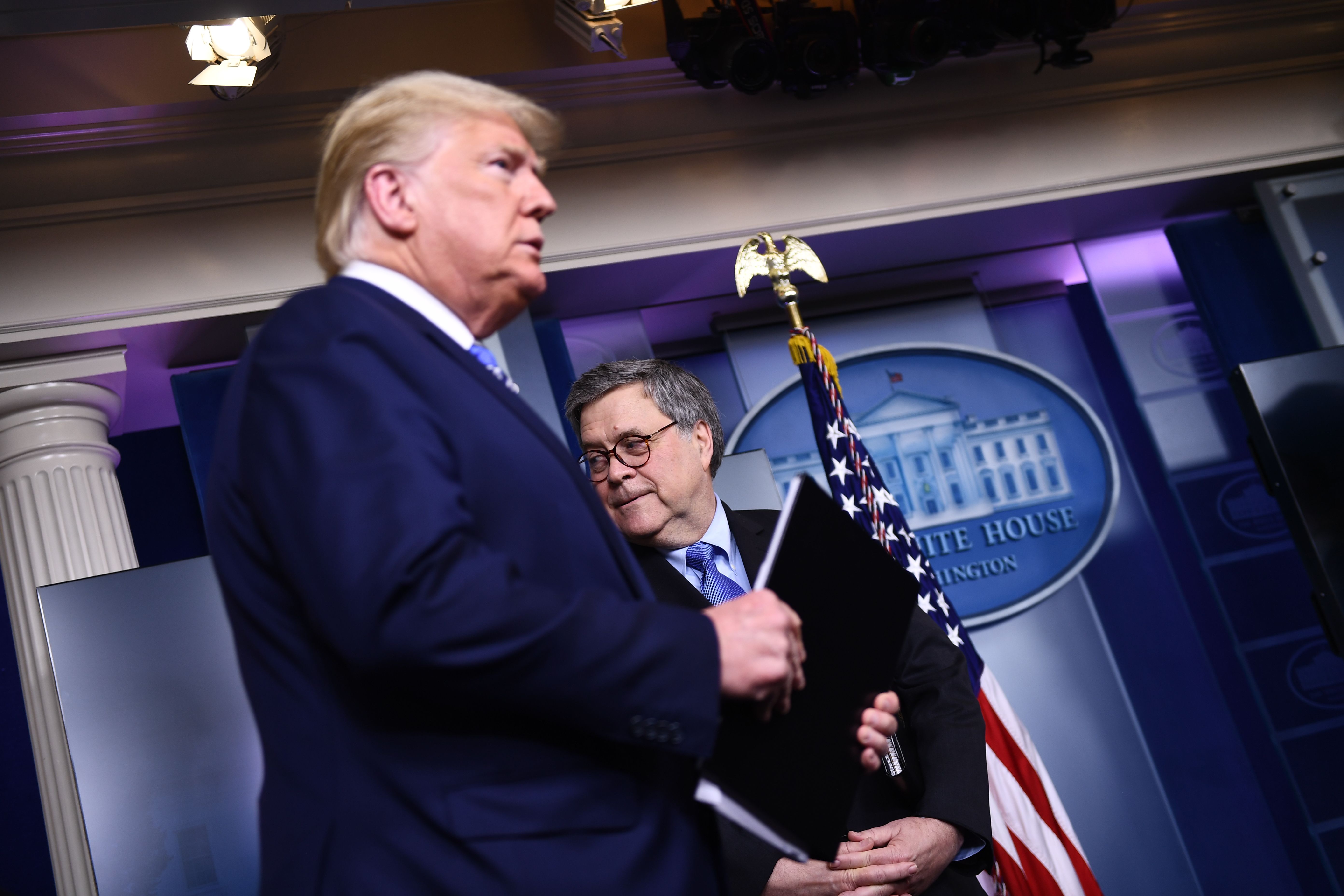 US President Donald Trump arrives as Attorney General William Barr looks on during the daily briefing on the novel coronavirus, COVID-19, at the White House on March 23, 2020, in Washington, DC. (Photo by BRENDAN SMIALOWSKI/AFP via Getty Images)