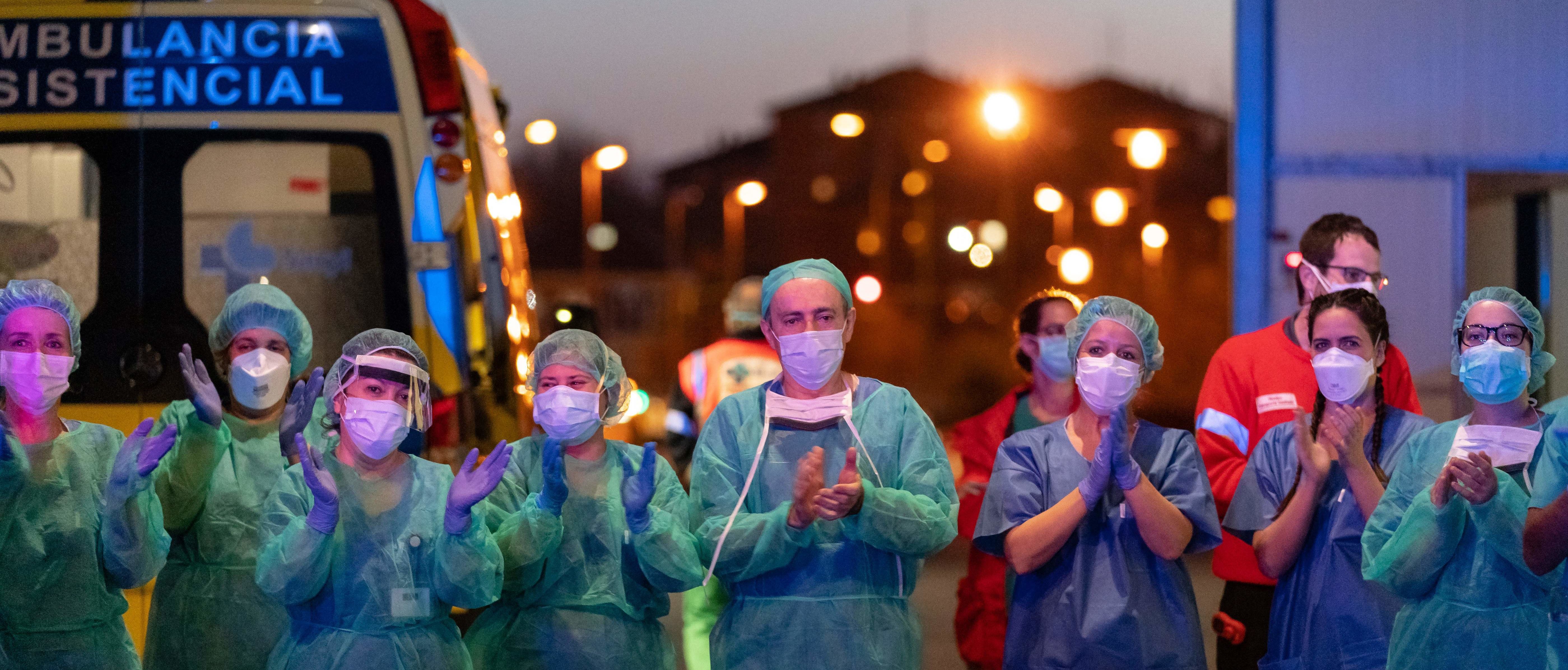 Healthcare workers dealing with the new coronavirus crisis applaud in return as they are cheered on by people outside the Burgos general hospital in Burgos on March 25, 2020. - (Photo by CESAR MANSO/AFP via Getty Images)