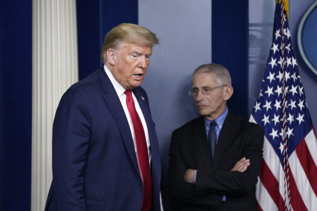 President Donald Trump arrives as National Institute of Allergy and Infectious Diseases Director Anthony Fauci waits for the beginning of a briefing on the coronavirus pandemic in the press briefing room of the White House on March 26, 2020 in Washington, DC. The U.S. House of Representatives is scheduled to vote Friday on the $2 trillion stimulus package to combat the effects of the COVID-19 pandemic. (Photo by Drew Angerer/Getty Images)