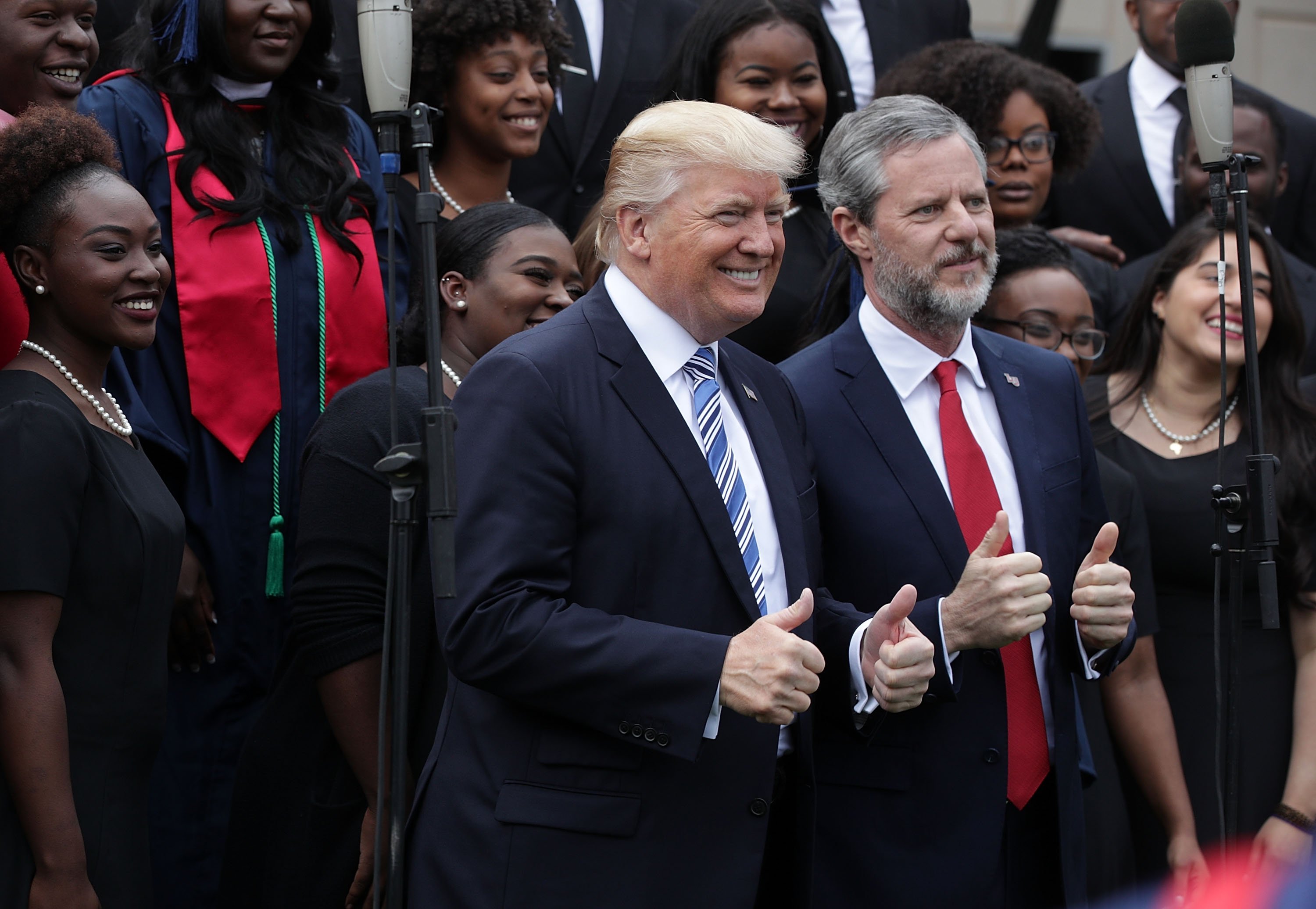 LYNCHBURG, VA - MAY 13: U.S. President Donald Trump (L) and Jerry Falwell (R), President of Liberty University, pose for photos with members of gospel choir Lu Praise during a commencement at Liberty University May 13, 2017 in Lynchburg, Virginia. President Trump is the first sitting president to speak at Liberty's commencement since George H.W. Bush spoke in 1990. (Photo by Alex Wong/Getty Images)