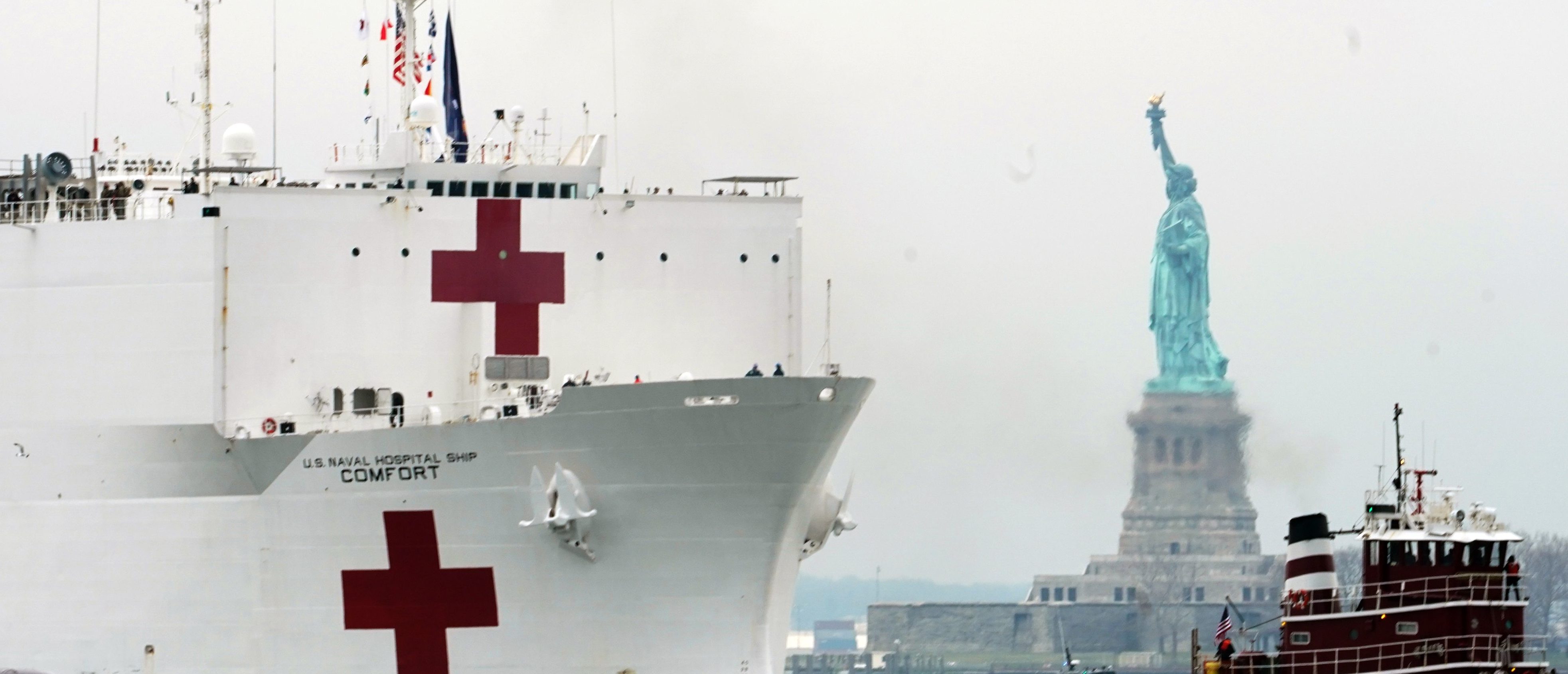 The USNS Comfort medical ship moves up the Hudson River past the Statue of Liberty as it arrives on March 30, 2020 in New York. Photo by BRYAN R. SMITH/AFP