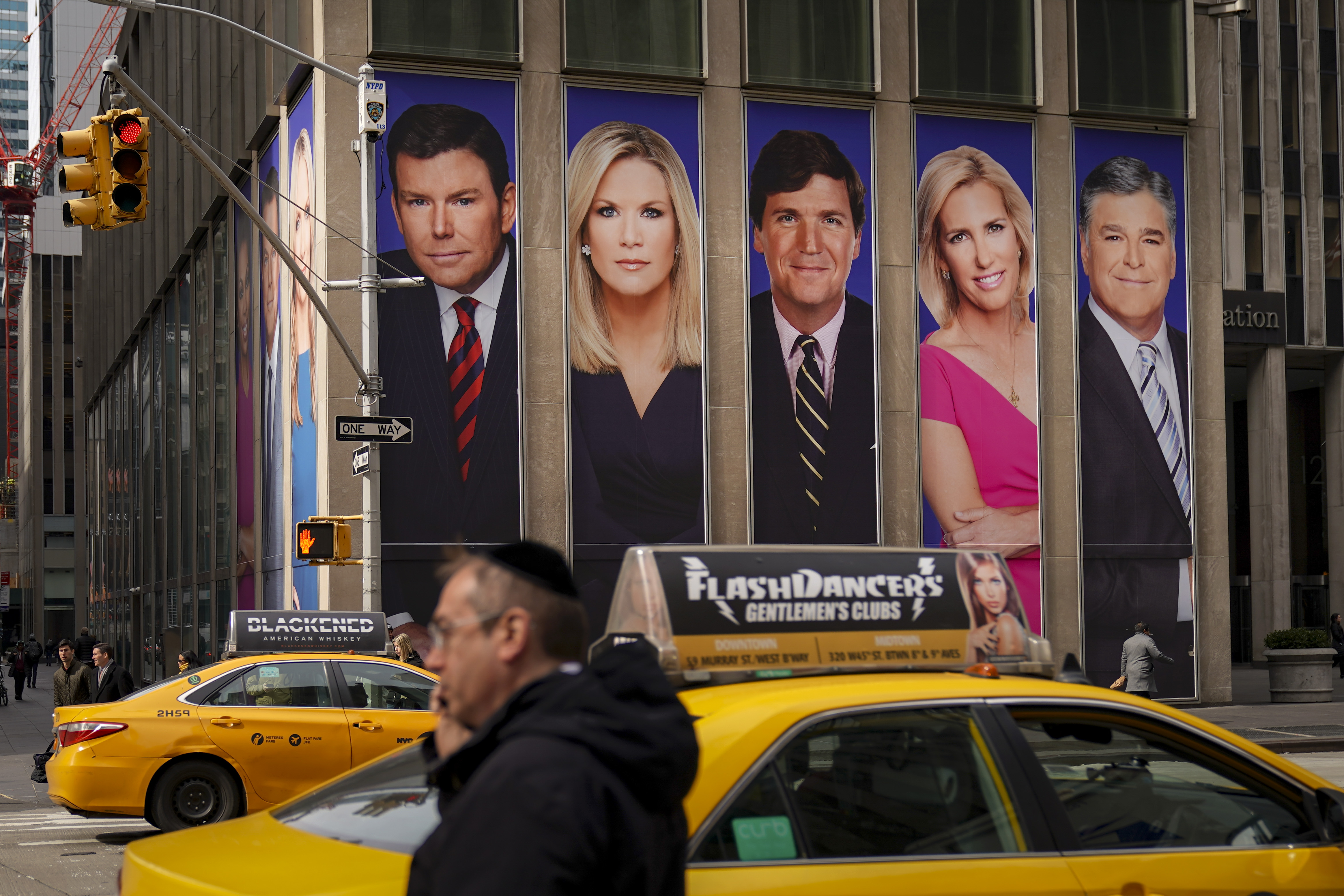 Traffic on Sixth Avenue passes by advertisements featuring Fox News personalities, including Bret Baier, Martha MacCallum, Tucker Carlson, Laura Ingraham, and Sean Hannity, adorn the front of the News Corporation building, March 13, 2019 in New York City. (Drew Angerer/Getty Images)