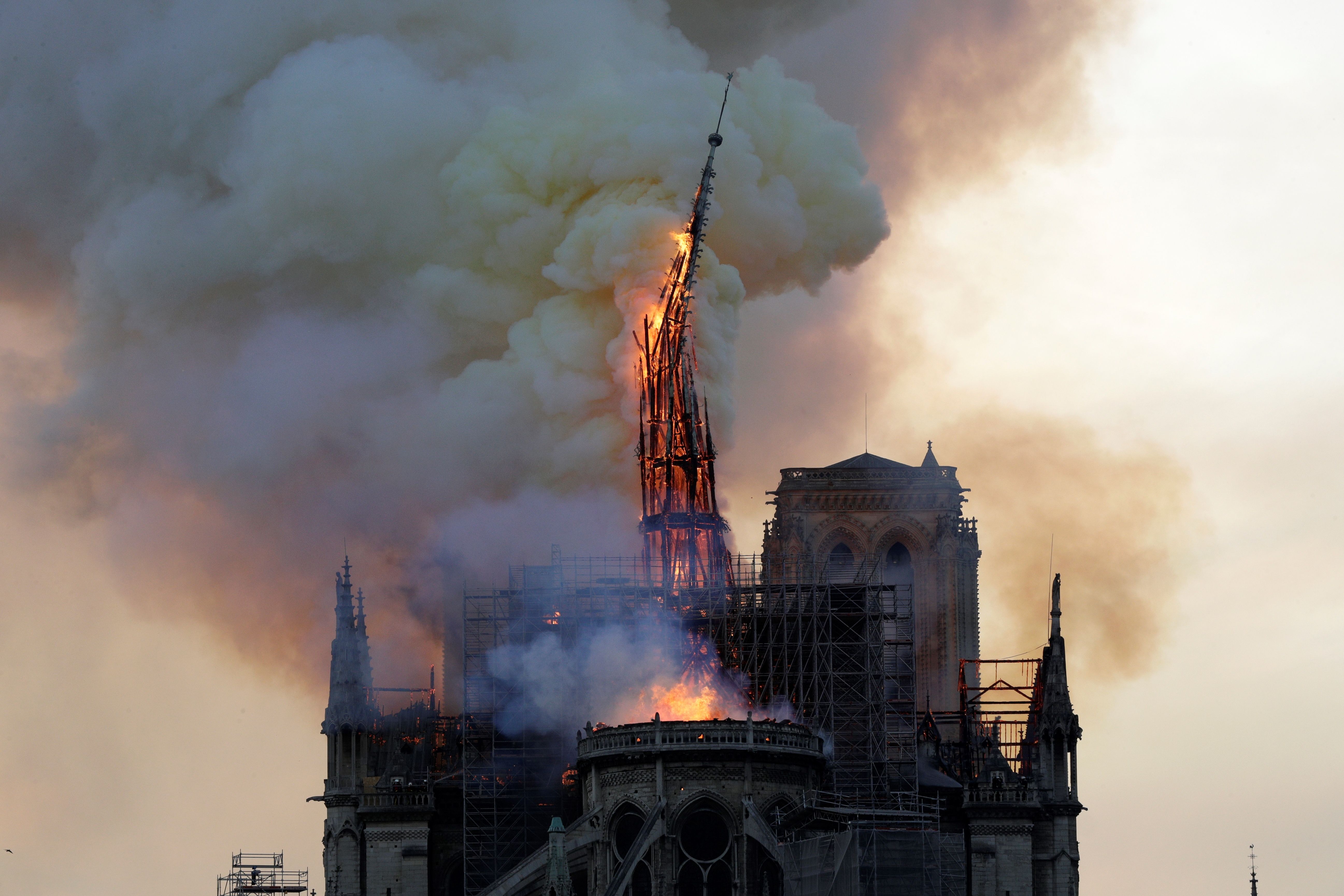 The steeple and spire of the landmark Notre-Dame Cathedral collapses as the cathedral is engulfed in flames in central Paris on April 15, 2019. (Photo by GEOFFROY VAN DER HASSELT/AFP via Getty Images)