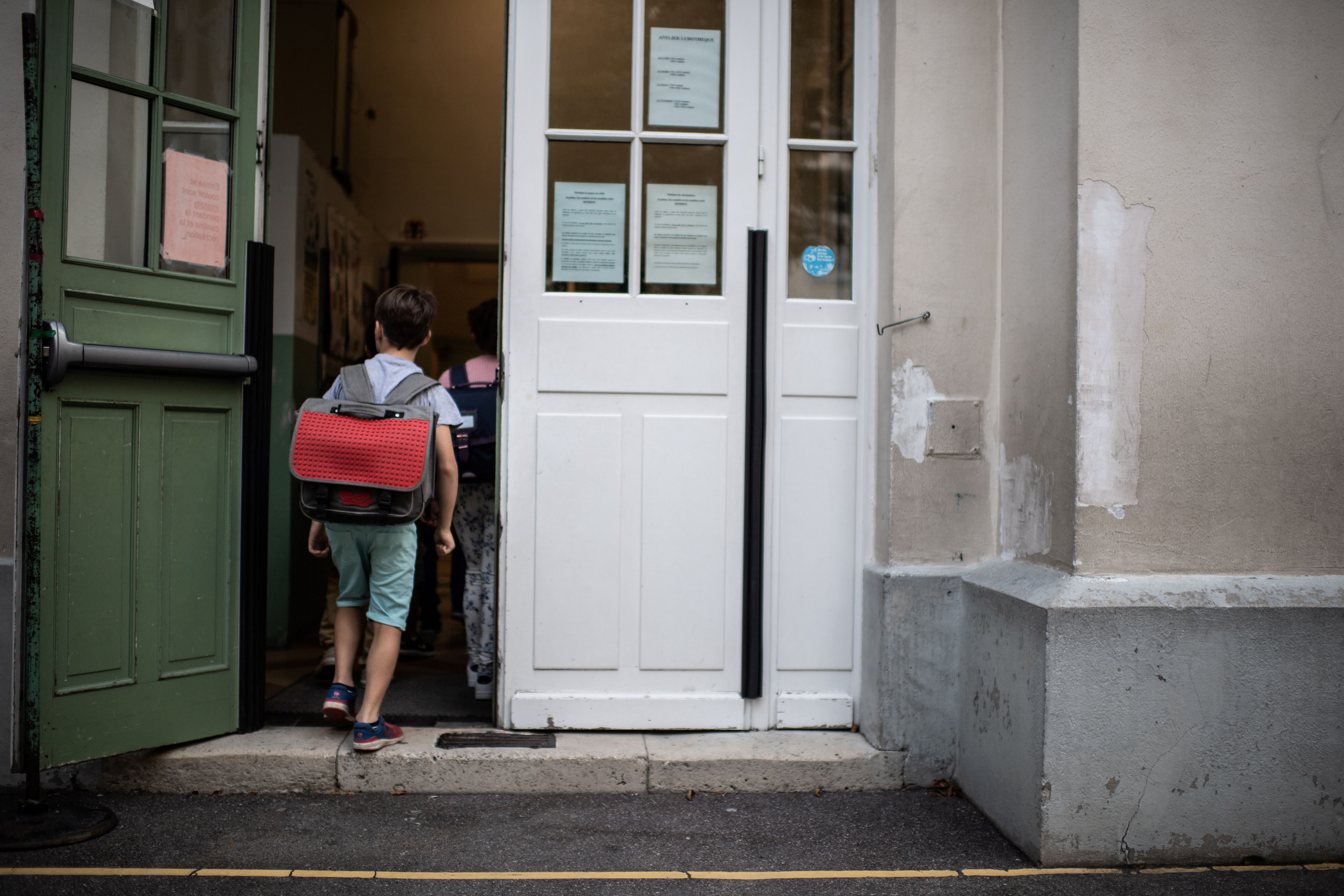 A boy enters in his classroom on the first day of the start of the school year, at the Chaptal elementary school in Paris. (MARTIN BUREAU/AFP via Getty Images)