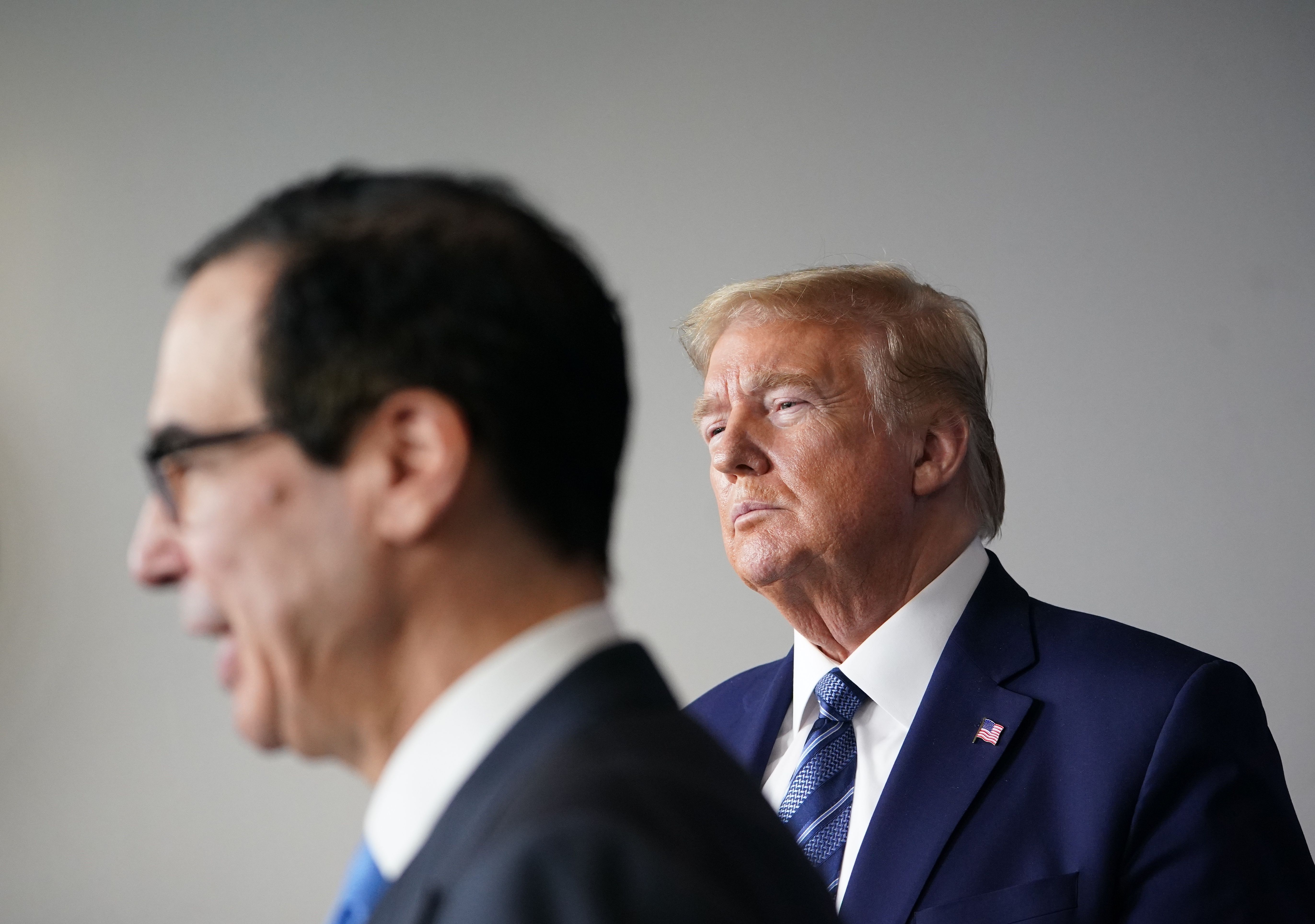 US President Donald Trump listens as Treasury Secretary Steven Mnuchin speaks during the daily briefing on the novel coronavirus, COVID-19, in the Brady Briefing Room of the White House in Washington, DC on April 21, 2020. (Photo by MANDEL NGAN/AFP via Getty Images)
