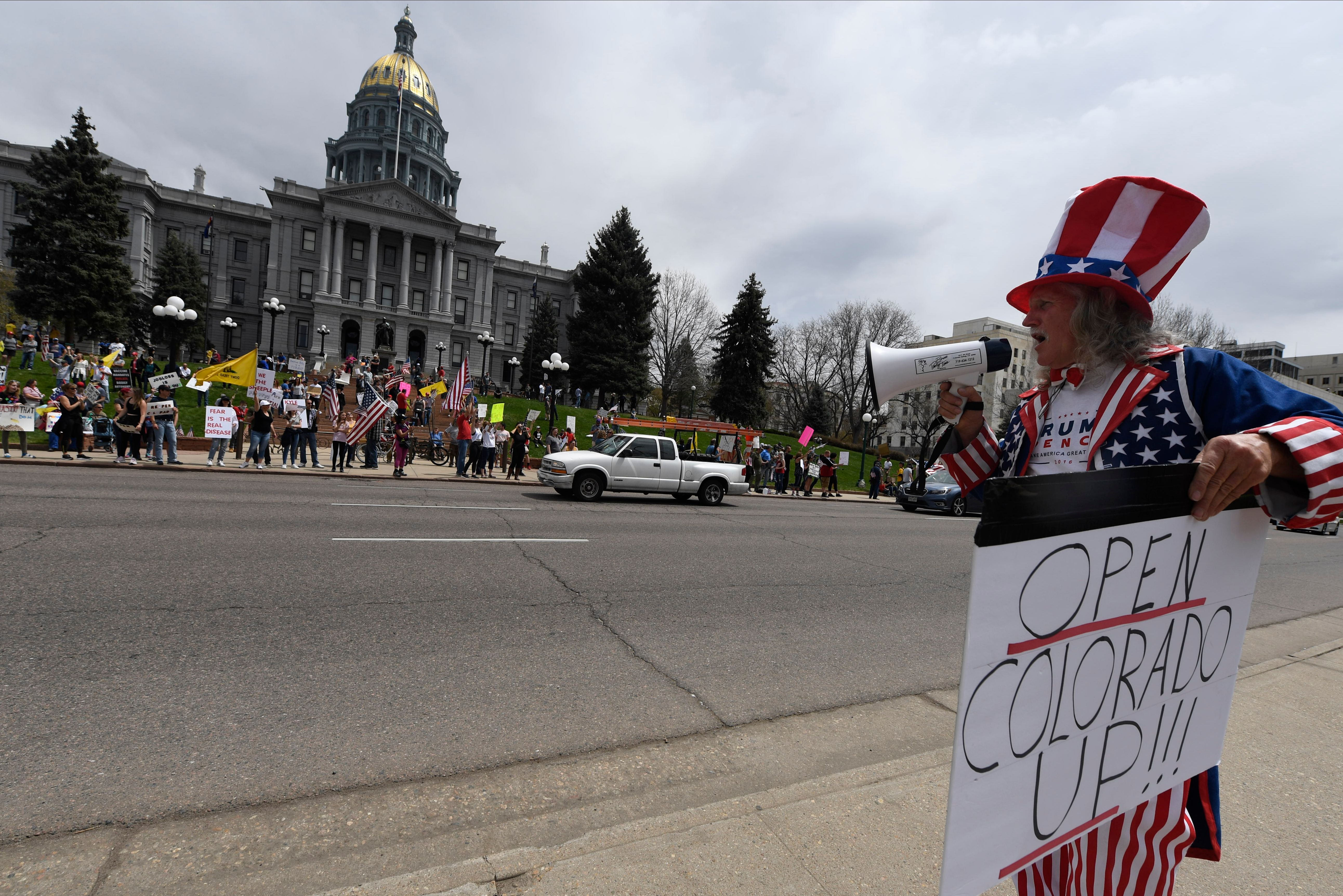 Jim Fenimore of Colorado Springs, Colorado wears an Uncle Sam outfit while protesting against new safer-at-home orders during the End the Lockdown Now rally. (Photo by JASON CONNOLLY/Agence France-Presse/AFP via Getty Images)