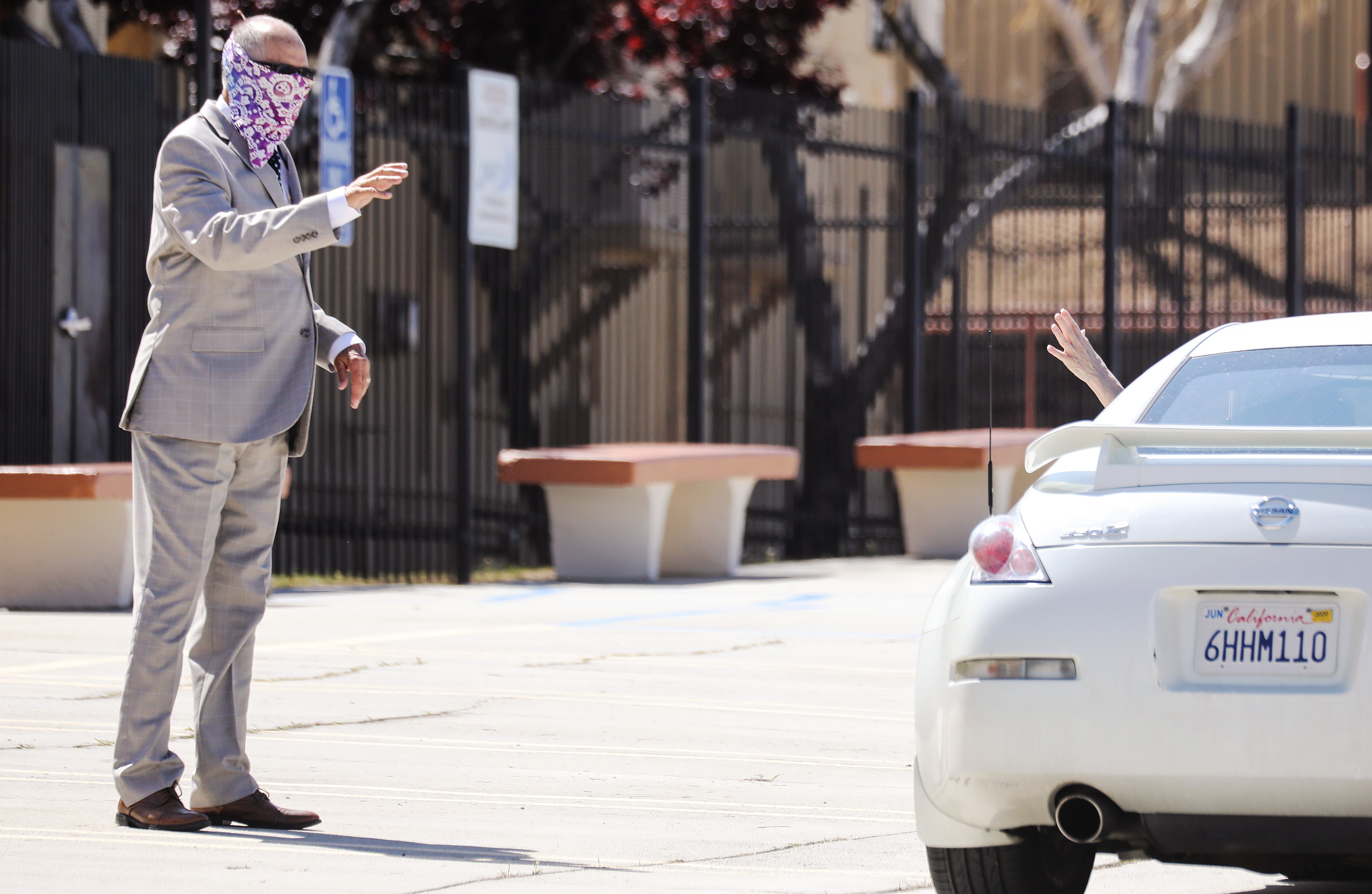 Pastor Jerel Hagerman (L) waves to a departing congregant after conducting a drive-in ‘car church’ Easter service (Mario Tama/Getty Images)