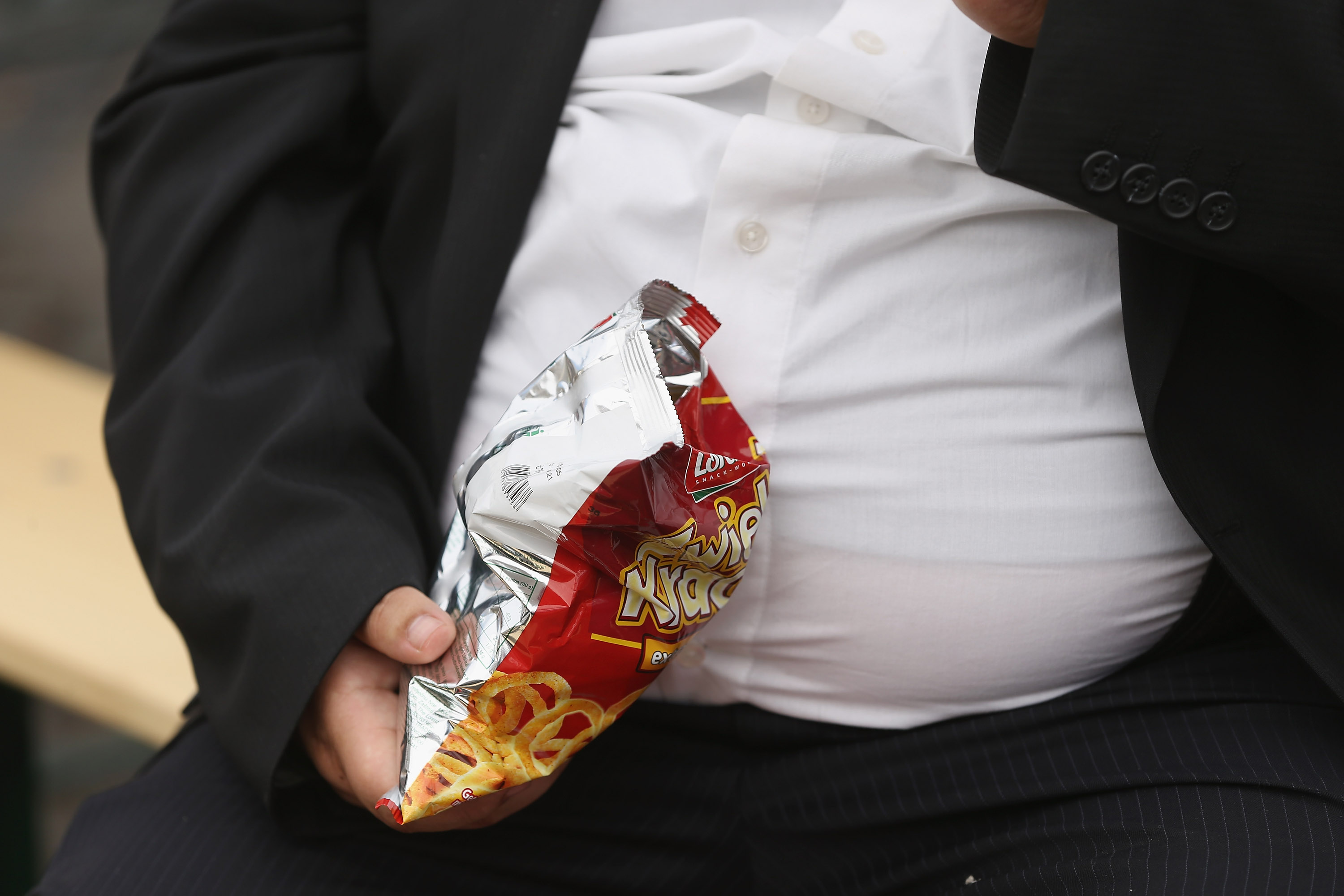 A man with a large belly eats junk food on May 23, 2013 in Leipzig, Germany. (Photo by Sean Gallup/Getty Images)