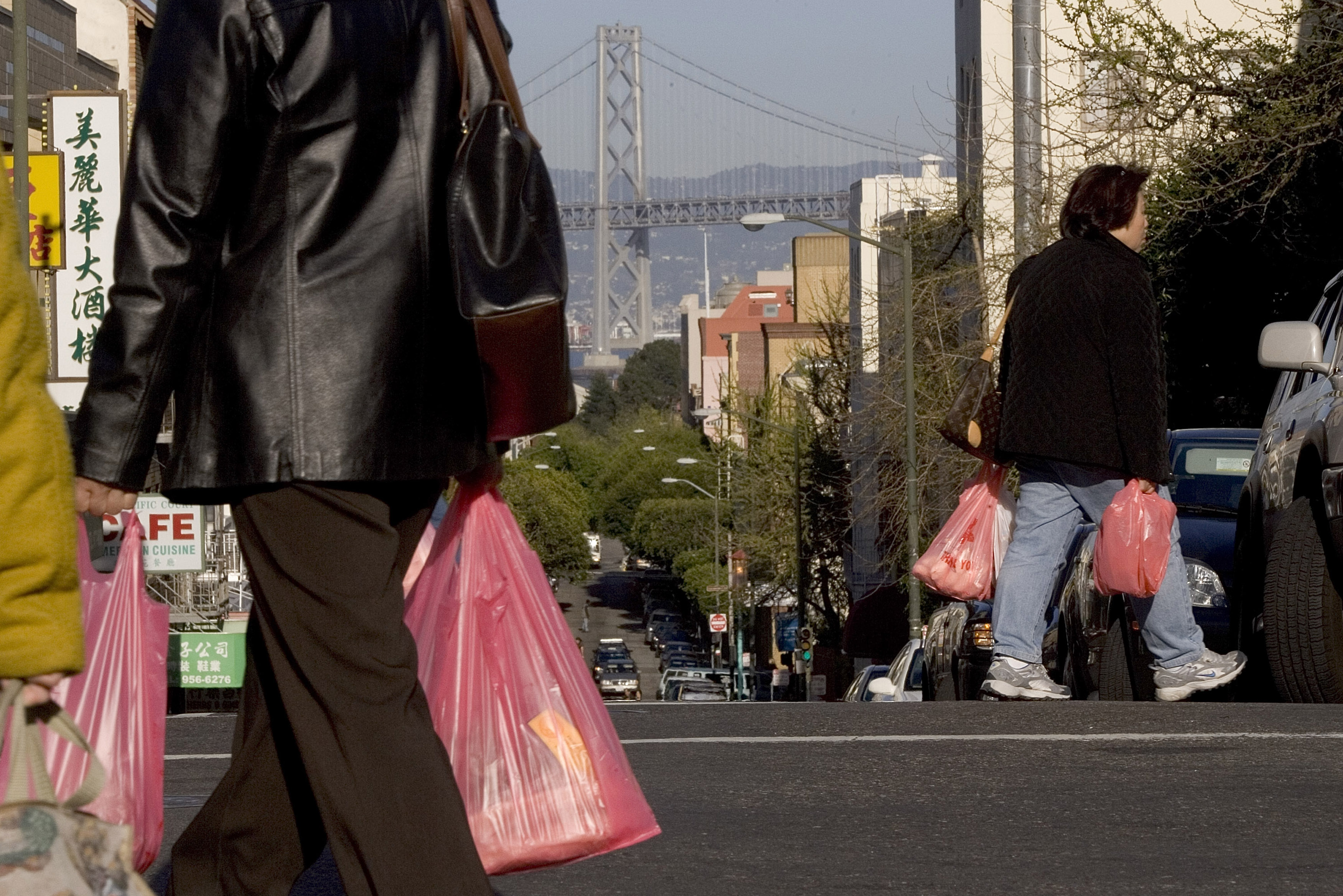 People walk with groceries in plastic bags in Chinatown on March 28, 2007 in San Francisco, (Photo by David Paul Morris/Getty Images)
