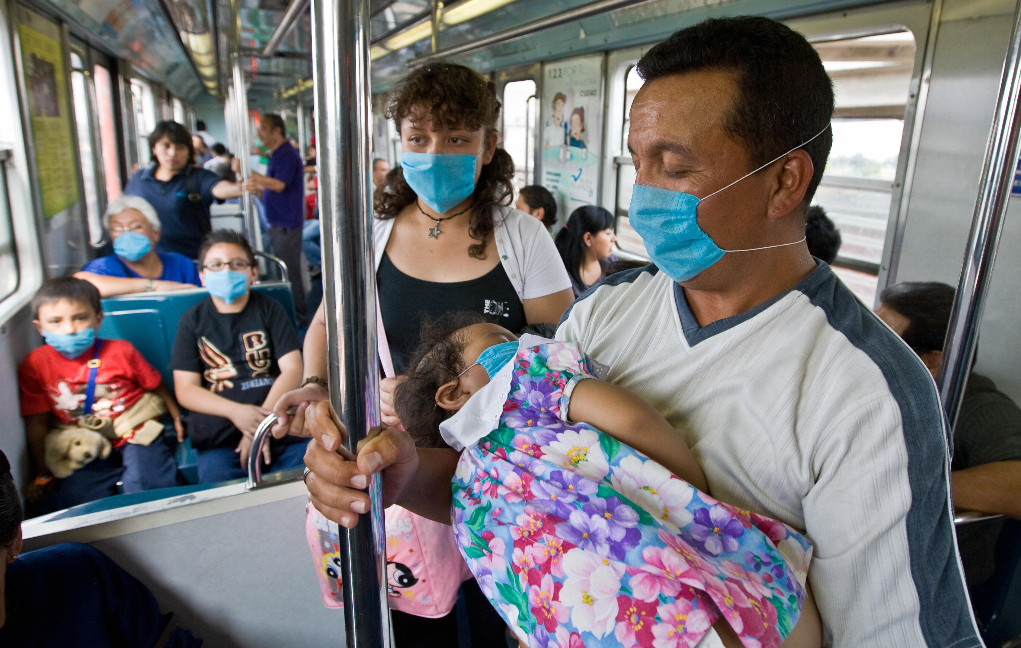 Commuters wear face masks to prevent the infection by the swine flu virus in while travelling aboard Mexico City's subway. (Ronaldo Schemidt/AFP via Getty Images)