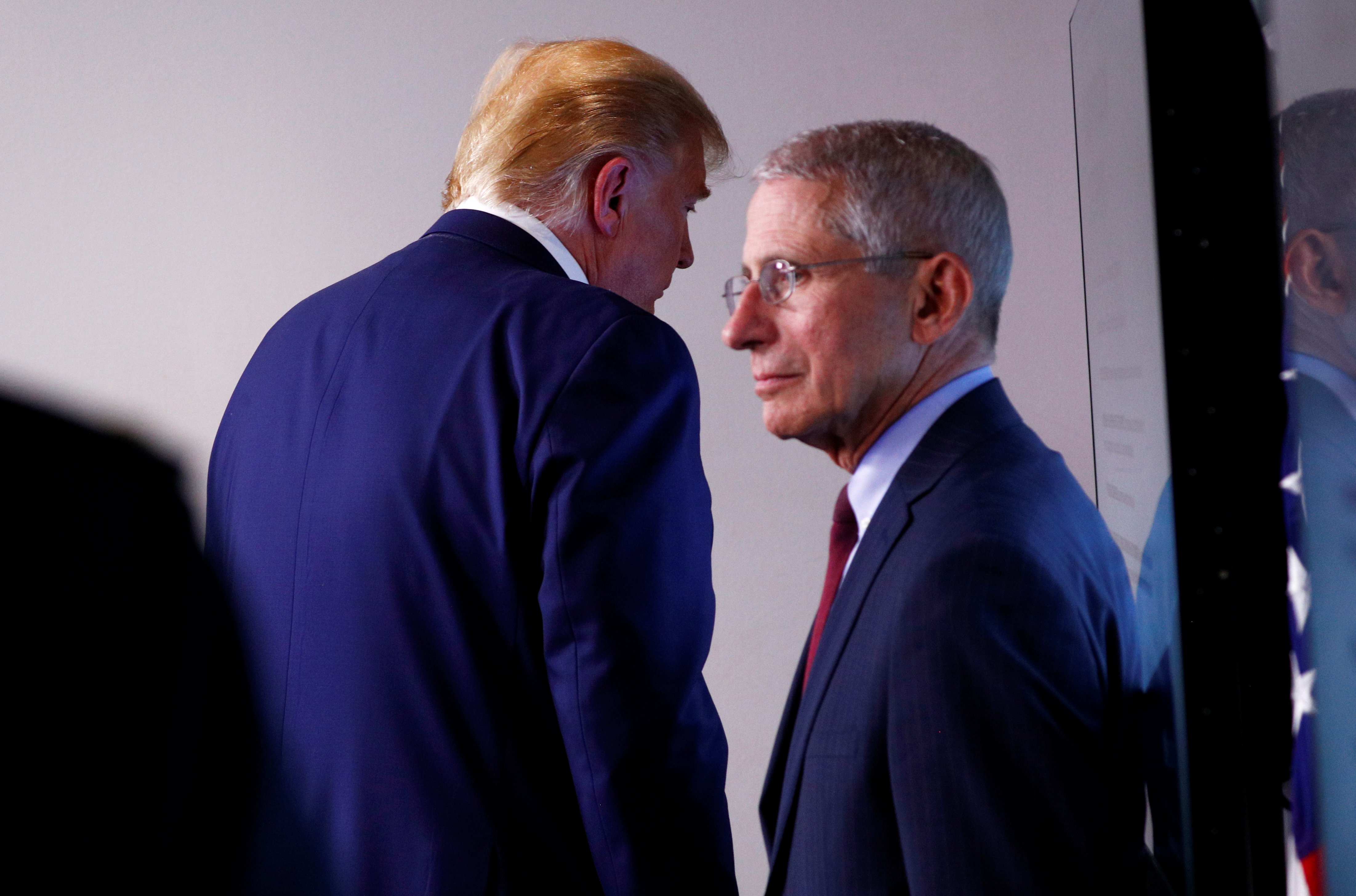 U.S. President Donald Trump leaves the room past Dr. Anthony Fauci, Director of the National Institute of Allergy and Infectious Diseases, at the conclusion of the daily coronavirus response briefing at the White House in Washington, U.S., March 31, 2020. REUTERS/Tom Brenner