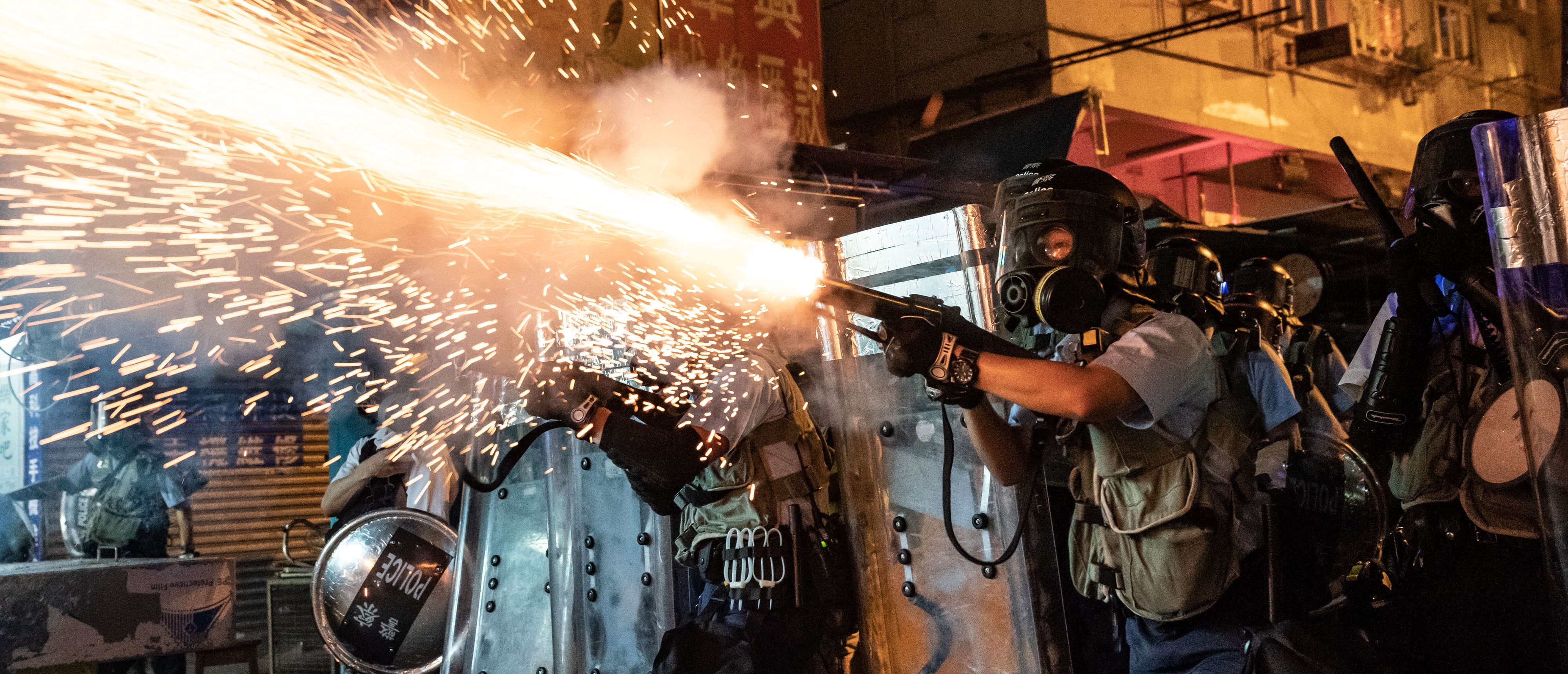 HONG KONG, CHINA - AUGUST 14: Police fire tear gas to clear pro-Democracy protesters during a demonstration on Hungry Ghost Festival day in the Sham Shui Po district on August 14, 2019 in Hong Kong, China. Protesters have continued rallies on the streets of Hong Kong against a controversial extradition bill since June 9 as the city plunged into crisis after waves of demonstrations and several violent clashes. Hong Kong's Chief Executive Carrie Lam apologized for introducing the bill and declared it "dead", however protesters have continued to draw large crowds with demands for Lam's resignation and complete withdrawal of the bill. (Photo by Anthony Kwan/Getty Images)