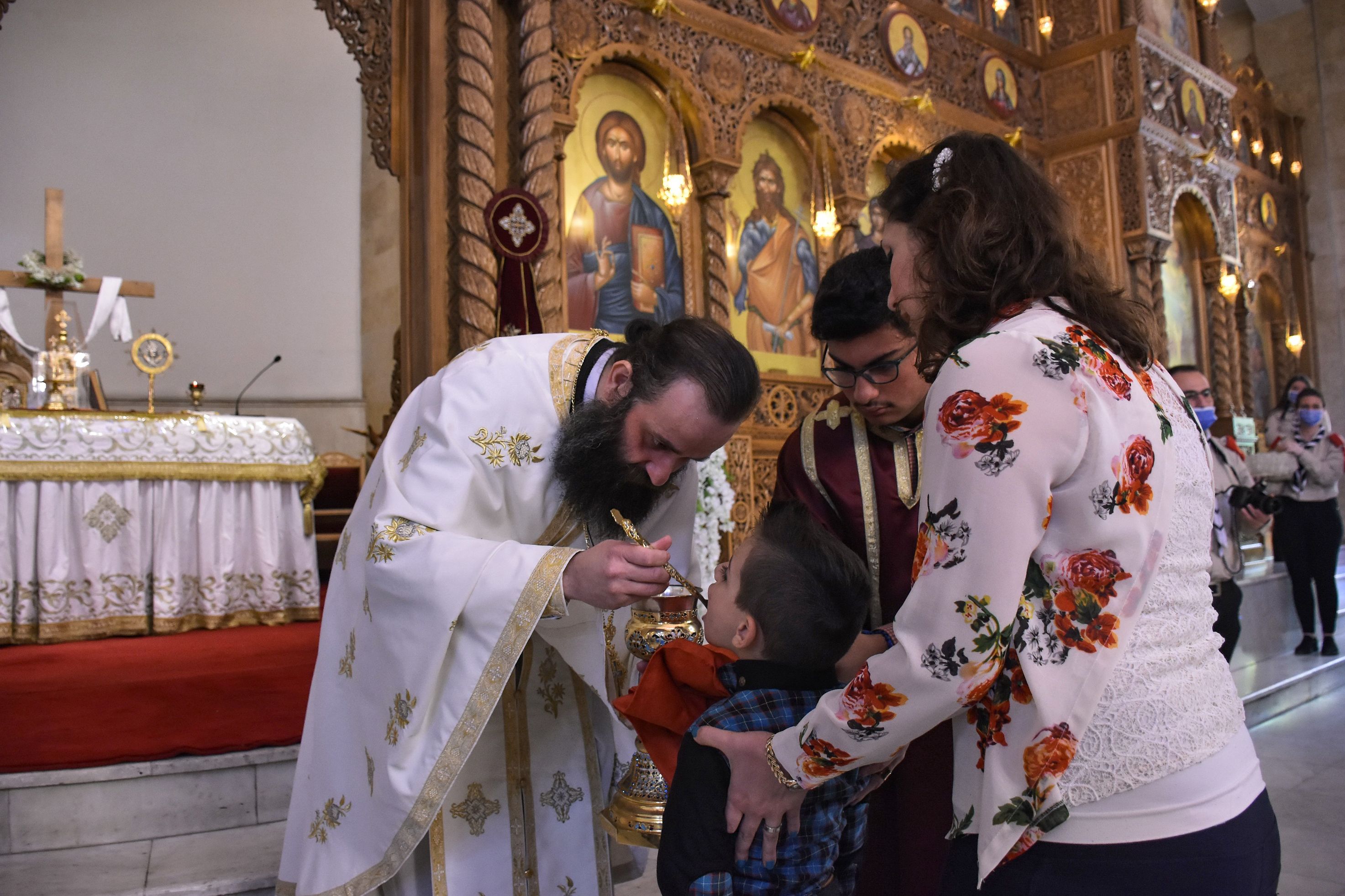 A child takes the communion from a Roman Orthodox priest following the Sunday mass at the Saint Elias church in the nothern Syrian city of Aleppo, on May 10, 2020. (Photo by -/AFP via Getty Images)