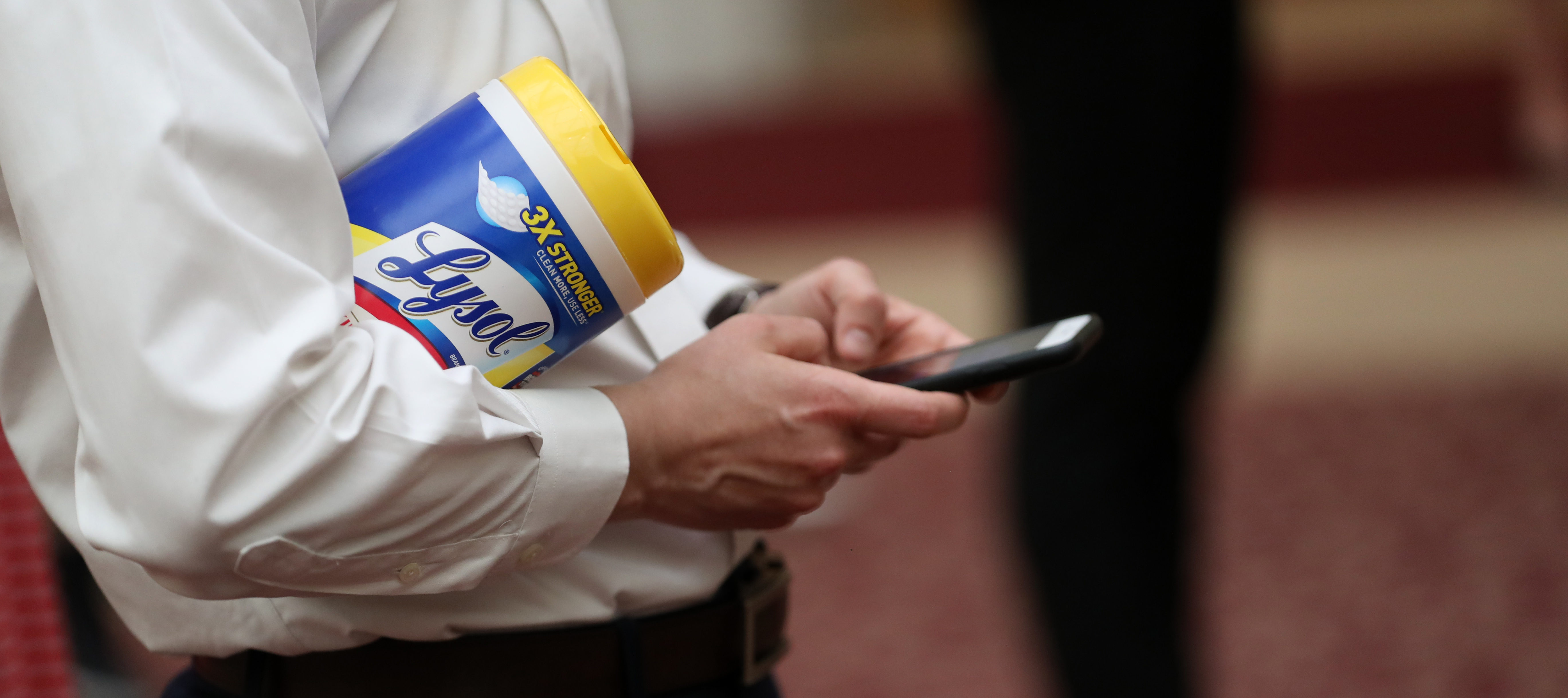 An attendee holds a container of Lysol disinfecting wipes as San Francisco Mayor London Breed (R) speaks during a press conference at San Francisco City Hall on March 16, 2020 in San Francisco, California. (Photo by Justin Sullivan/Getty Images)