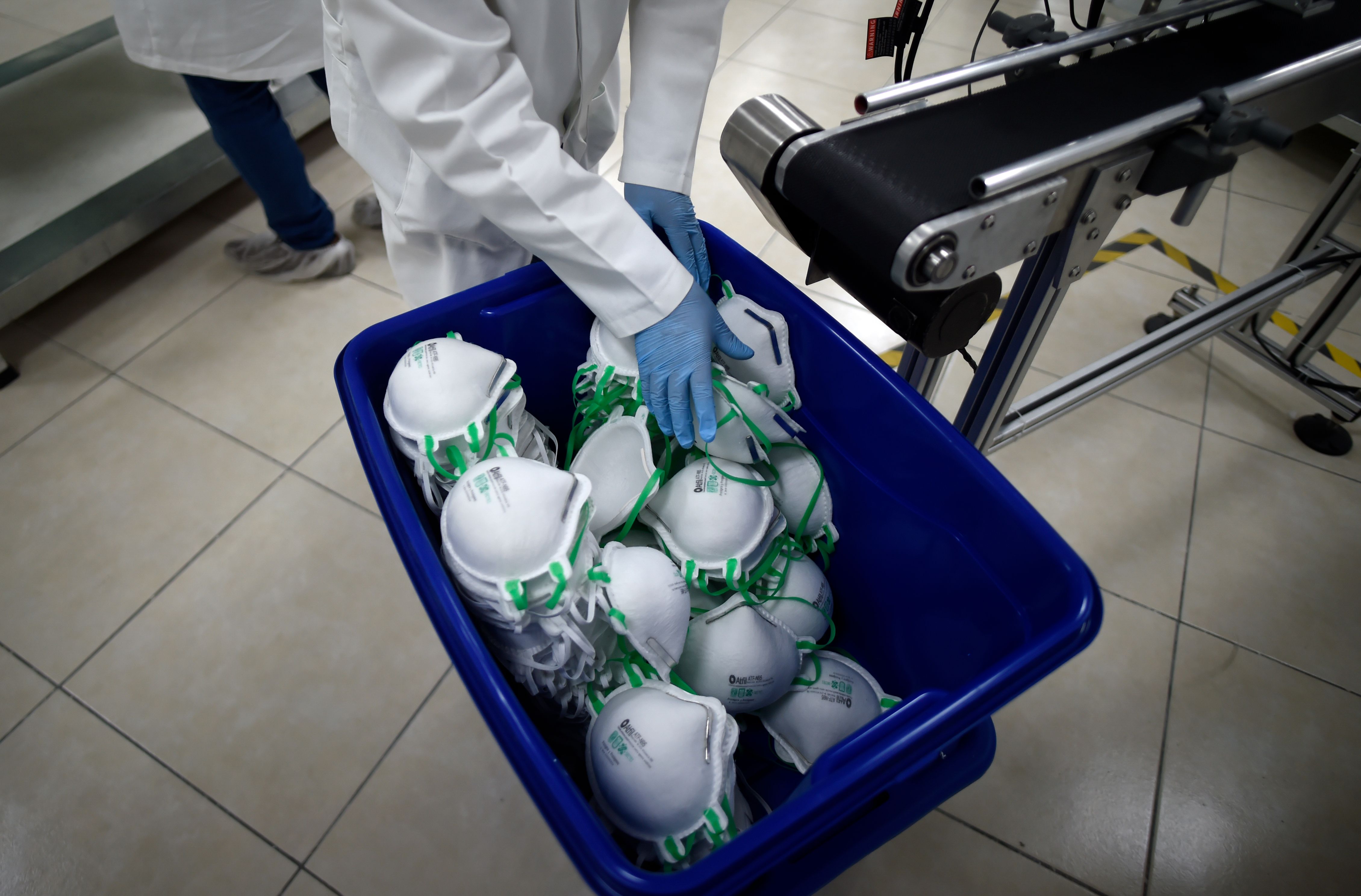 An employee arranges N95 face masks in a box, at a factory that produces 40,000 N95 masks per day, in Mexico City on May 21, 2020. (Photo by ALFREDO ESTRELLA/AFP via Getty Images)
