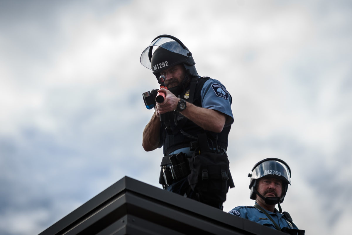Two police officers stand on the roof of the Third Police Precinct holding a projectile launcher during a demonstration in a call for justice for George Floyd following his death, outside the 3rd Police Precinct on May 27, 2020 in Minneapolis, Minnesota. (KEREM YUCEL/AFP via Getty Images)