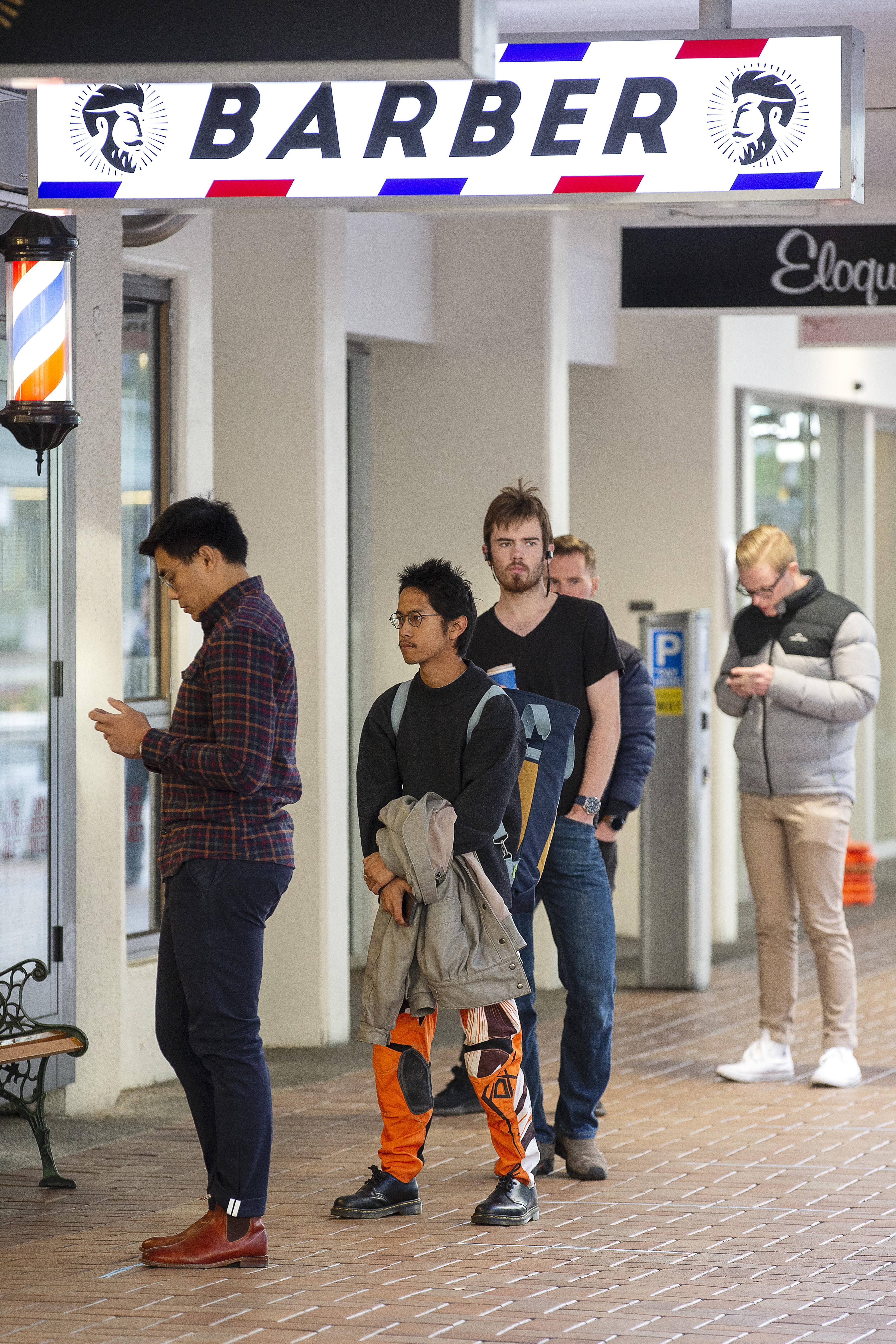 Customers queue up for a haircut at The French Barber on May 14, 2020 in Wellington, New Zealand. New Zealand moves to COVID-19 Alert Level 2 in three stages starting from today with restaurants, cinemas, retail, playgrounds and gyms able to reopen with physical distancing and strict hygiene measures in place. Public gatherings are permitted for up to 10 people and New Zealanders are now able to travel domestically. Schools and early childhood centres will open from Monday 18 May while bars will be allowed to reopen from Thursday 21 May. New Zealand was placed under full lockdown on March 26 in response to the coronavirus (COVID-19) pandemic. (Photo by Hagen Hopkins/Getty Images)
