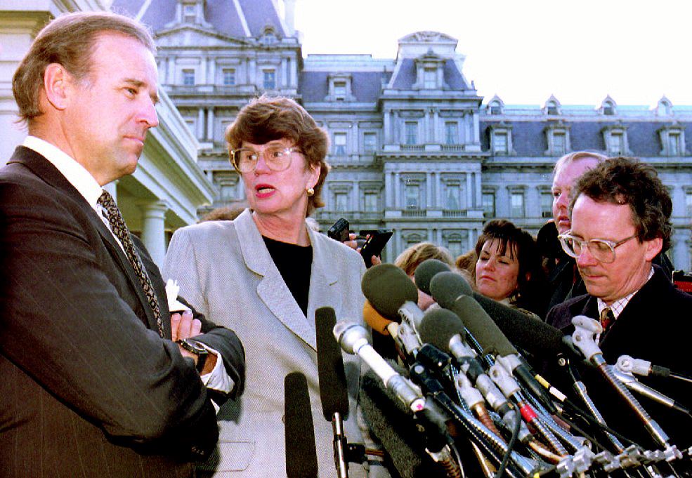 U.S. Attorney General Janet Reno (C), turns to answer a question from a reporter as she and Sen. Joseph Biden (L), D-Del, leave the White House after meeting with U.S. President Bill Clinton, 12 March 1993. (J.DAVID AKE/AFP via Getty Images)