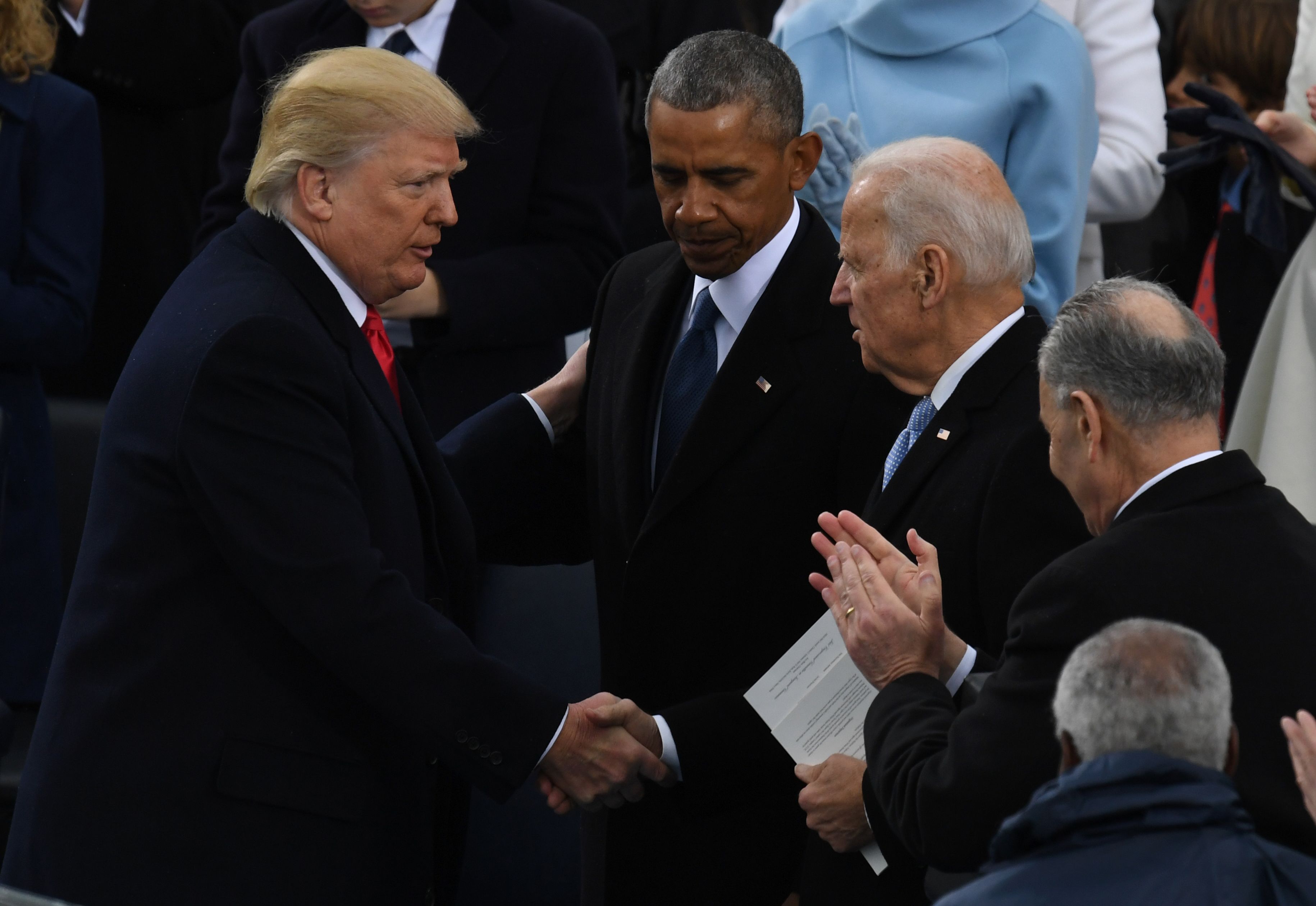US President Donald Trump (L) shakes hands with former US President Barack Obama (C) and former vice-President Joe Biden after being sworn in as President on January 20, 2017 at the US Capitol in Washington, DC. (MARK RALSTON/AFP via Getty Images)
