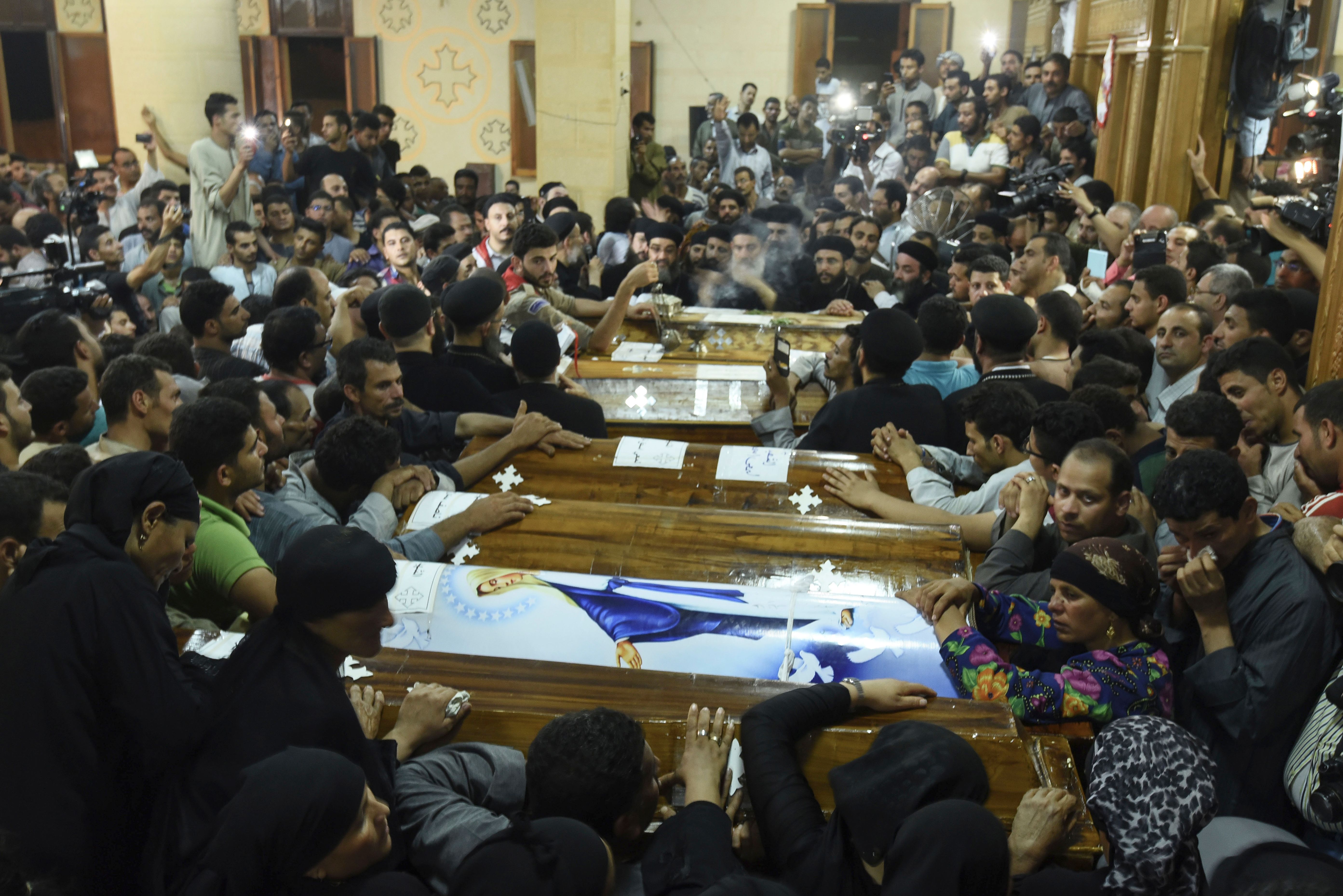 Relatives of killed Coptic Christians grieve by the coffins during the funeral at Abu Garnous Cathedral in the north Minya town of Maghagha, on May 26, 2017. (MOHAMED EL-SHAHED/AFP via Getty Images)