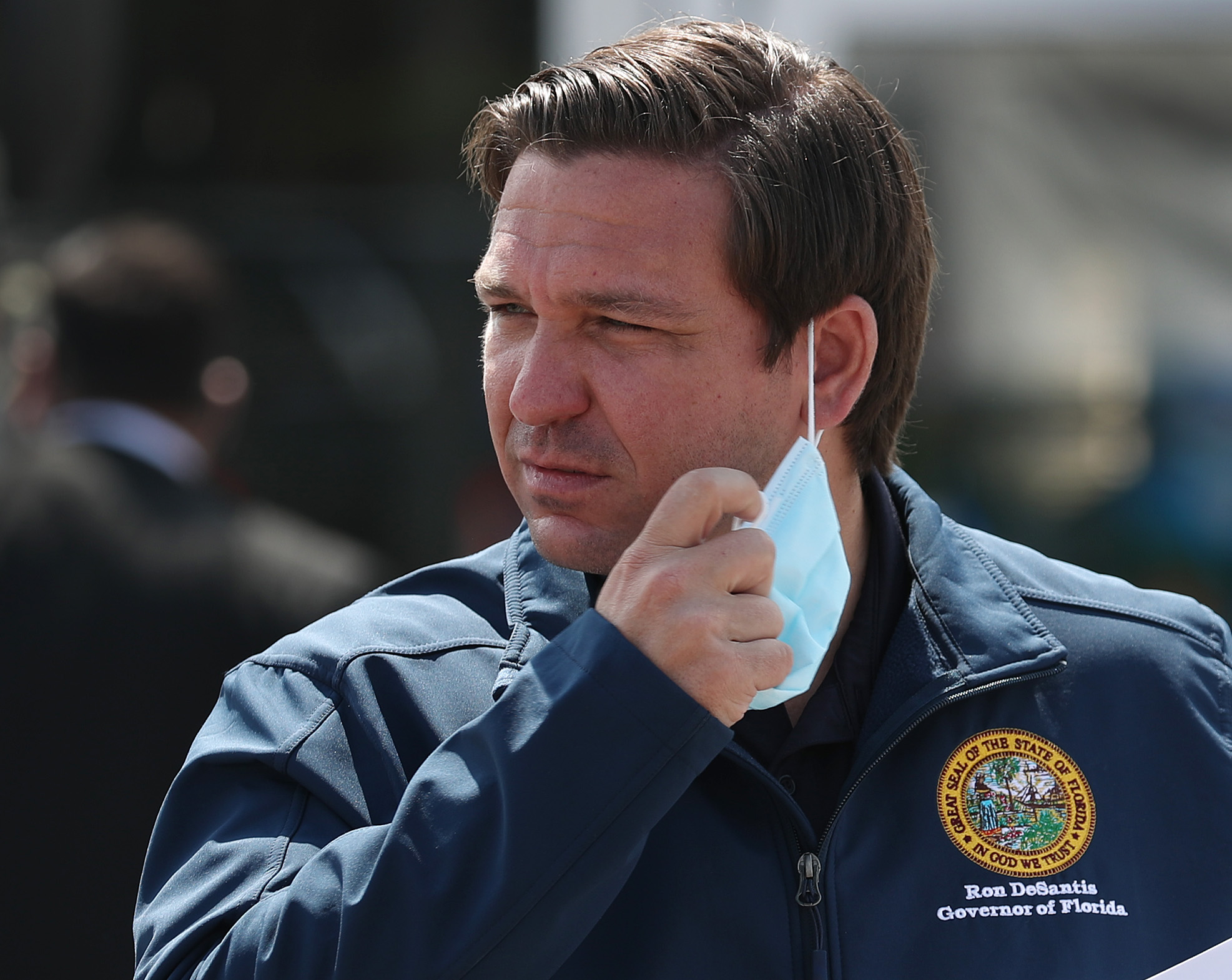 MIAMI GARDENS, FLORIDA - MAY 06: Florida Gov. Ron DeSantis takes his mask off as he prepares to speak during a press conference at the Hard Rock Stadium testing site on May 06, 2020 in Miami Gardens, Florida. Gov. DeSantis announced during the press conference that a COVID-19 antibodies test will be available. The test can show if a person has had the virus in the past without showing symptoms, and therefore may be immune to it. The test will be available to first responders and health care workers first, with the goal of being able to expand testing to the general public. (Photo by Joe Raedle/Getty Images)