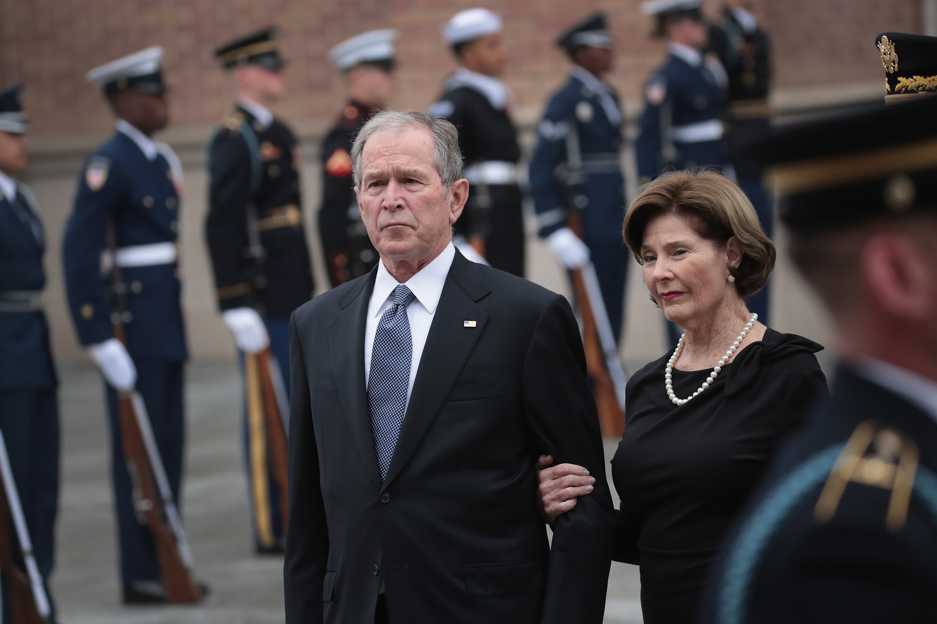 Former President George W. Bush and his wife Laura watch as the honor guard passes after loading the casket of President George H.W. Bush into a hearse outside St. Martin's Episcopal Church following his funeral service December 6, 2018 in Houston, Texas. (Scott Olson/Getty Images)