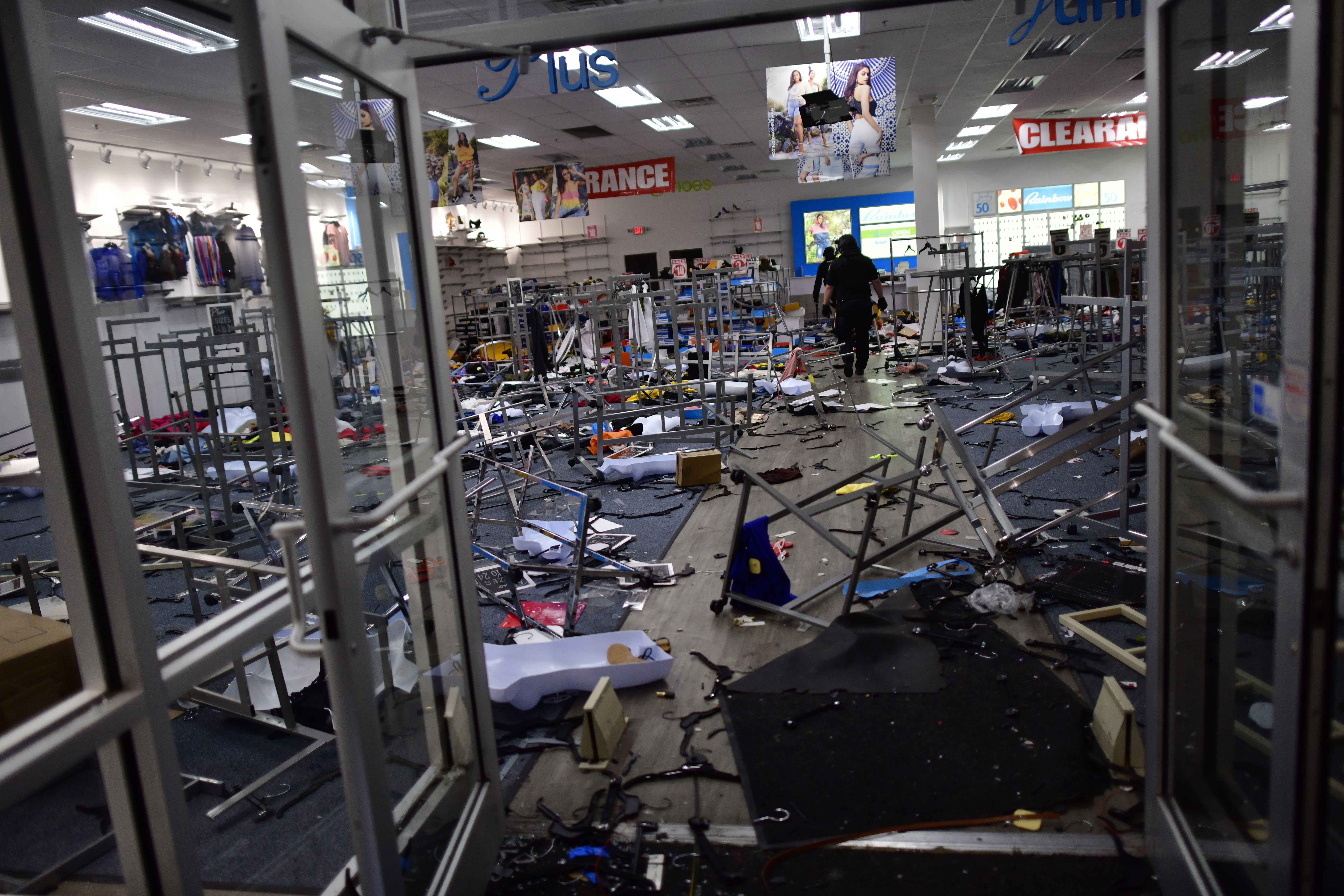 Police investigate a looted clothing store during widespread unrest following the death of George Floyd on May 31, 2020 in Philadelphia, Pennsylvania. (Photo by Mark Makela/Getty Images)