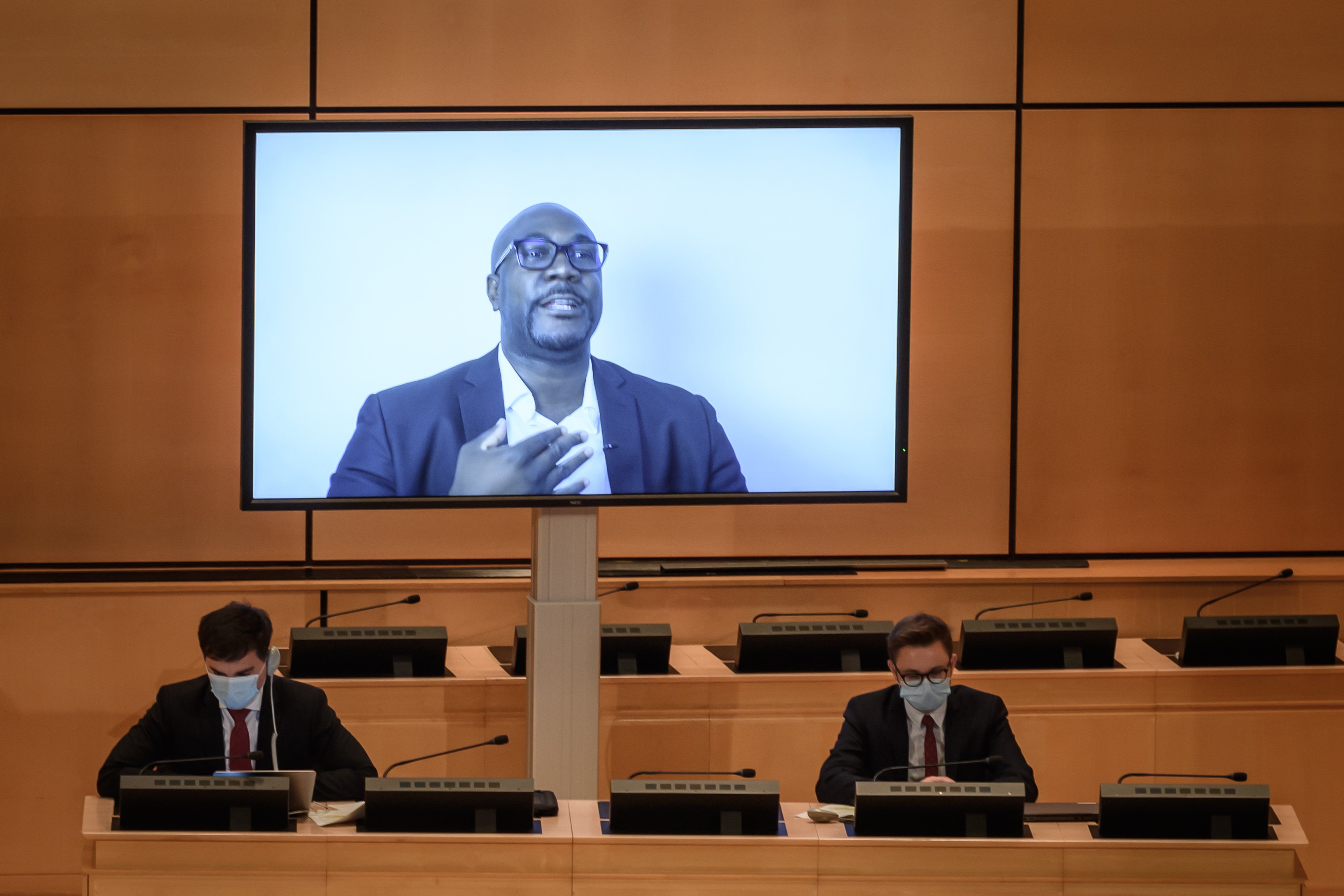 George Floyd's brother Philonise is seen on a TV screen during his speech at the opening of an urgent debate on "systemic racism" in the United States and beyond at the Human Rights Council on June 17, 2020 in Geneva. (Photo by FABRICE COFFRINI/AFP via Getty Images)