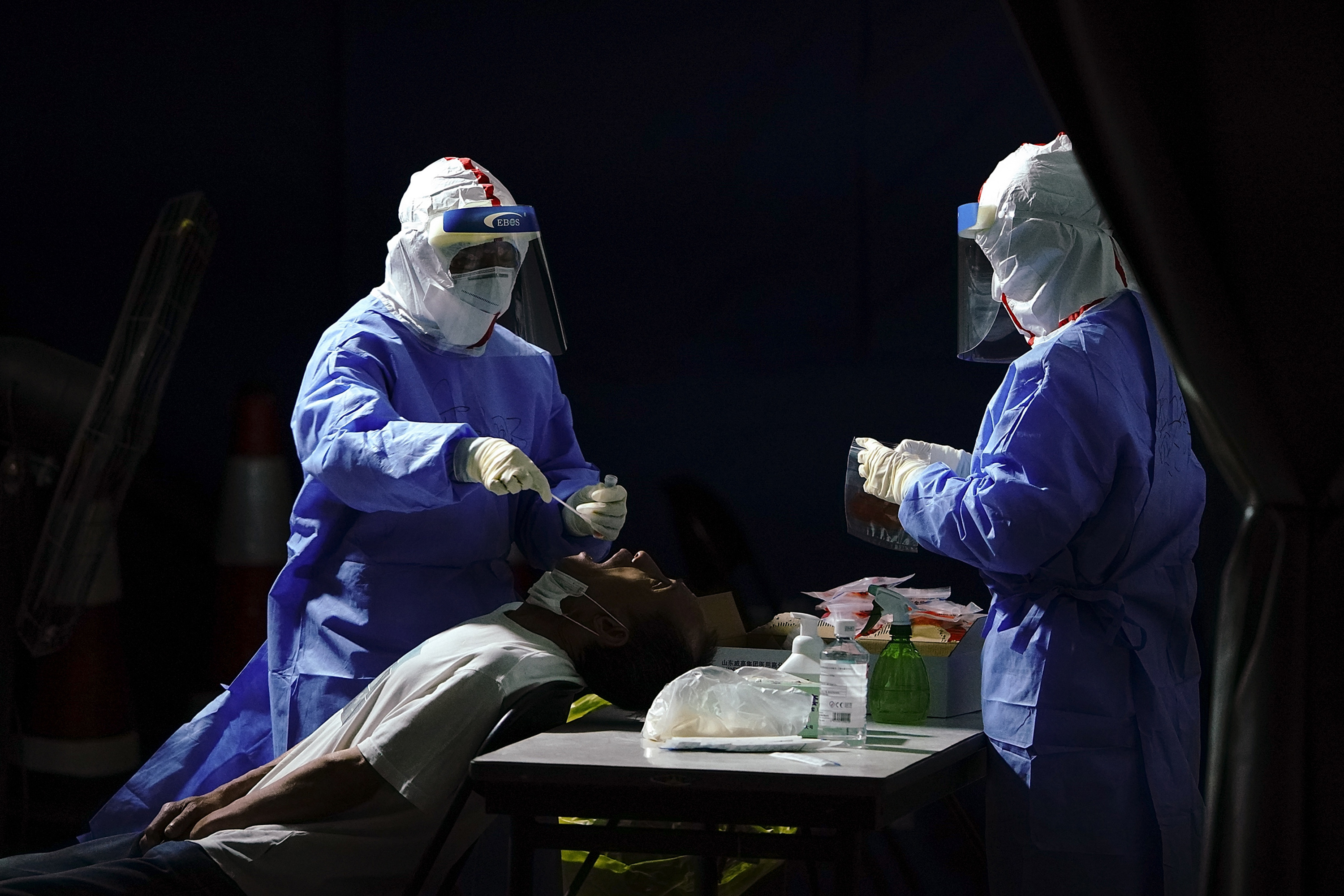 A nurse wearing a protective suit and mask takes a nucleic acid test for COVID-19 from a person who either visited or lives near the Xinfadi Market at a testing facility at a Sport Center on June 17, 2020 in Beijing, China. The authorities in Beijing have begun an operation to contain a potential second wave of coronavirus after 137 new cases were detected, the most in nine weeks. (Photo by Lintao Zhang/Getty Images)