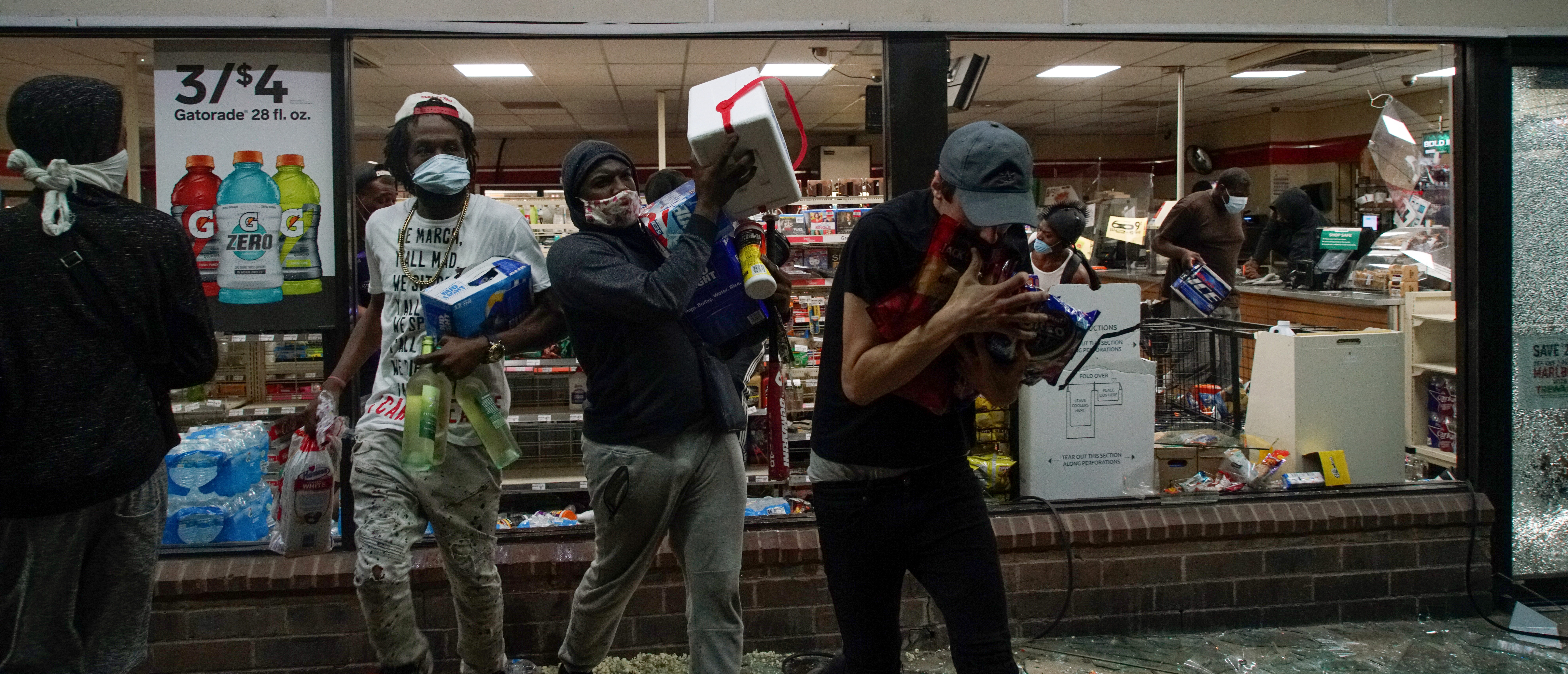 Looters come out a broken window of a 7-11 during a protest against the death in Minneapolis police custody of African-American man George Floyd, in St Louis, Missouri, U.S., June 1, 2020. REUTERS/Lawrence Bryant