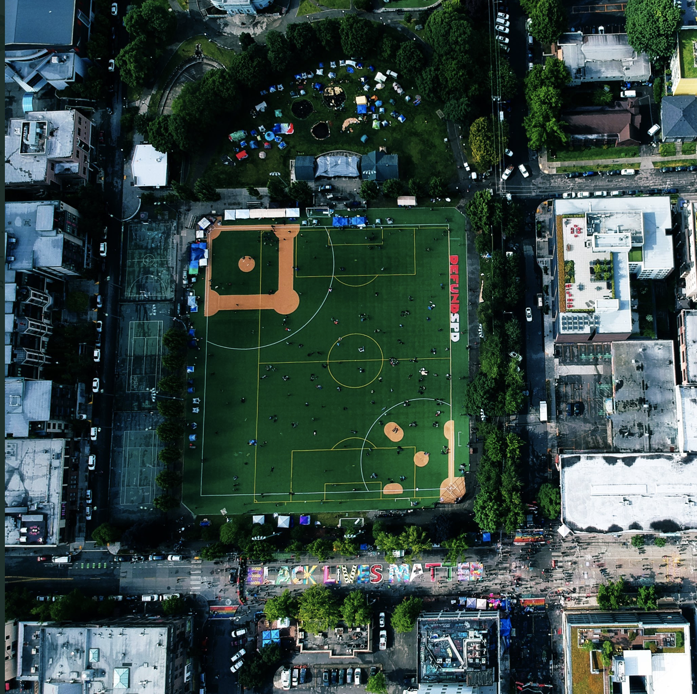 An aerial view of CHAZ after being taken over by protesters shows tents inside the park and a large mural on street. (Credit: Richie McGinniss)