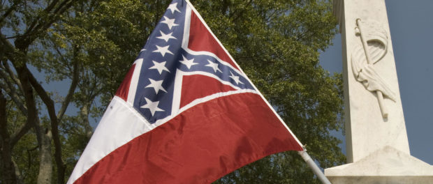 Anthony Hervey stands in the town square waving his Mississippi state flag. PAUL J. RICHARDS/AFP via Getty Images