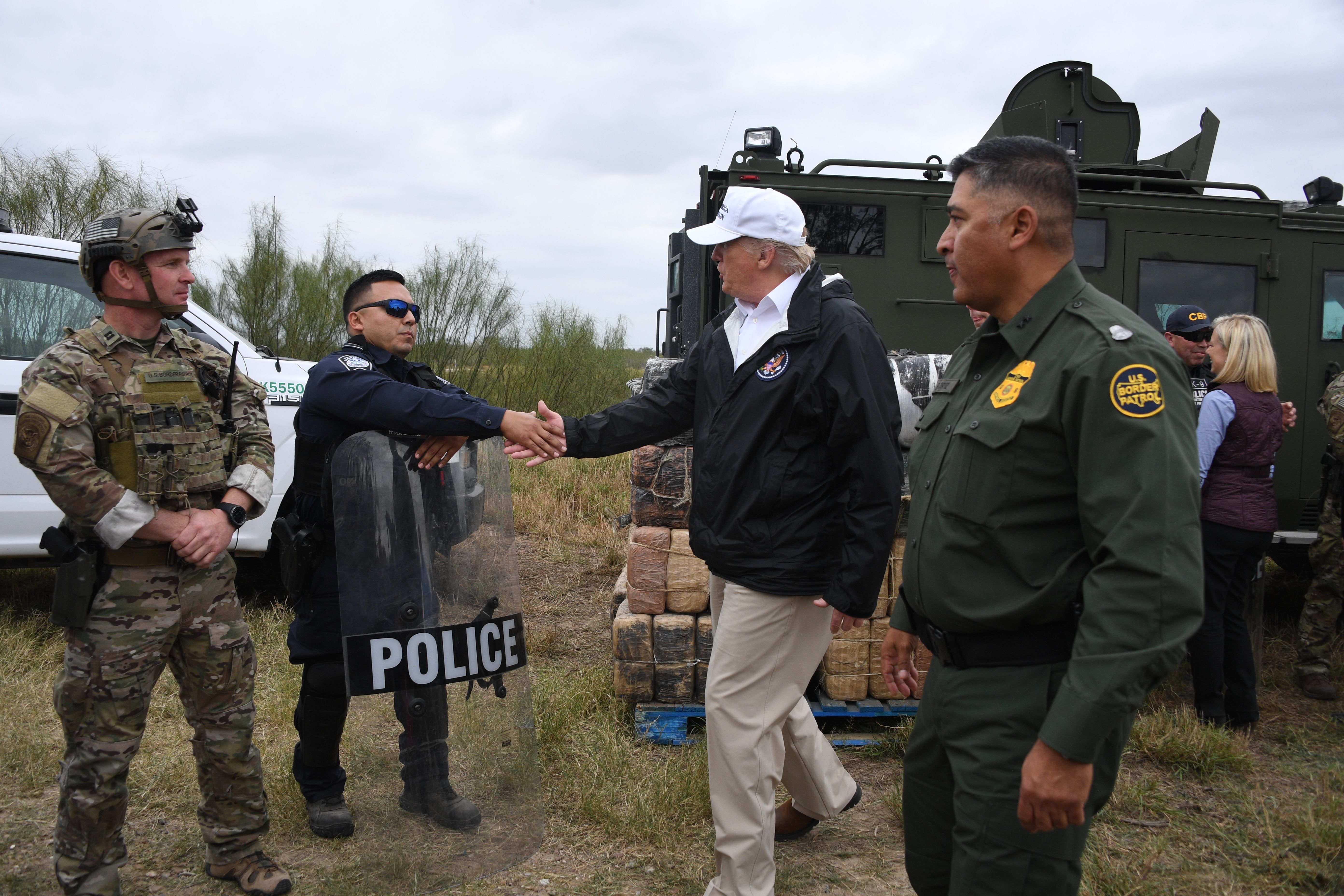 US President Donald Trump(C) greets a policeman with Border Patrol agents,and military after his visit to US Border Patrol McAllen Station in McAllen, Texas, on January 10, 2019. - Trump traveled to the US-Mexico border as part of his all-out offensive to build a wall, a day after he stormed out of negotiations when Democratic opponents refused to agree to fund the project in exchange for an end to a painful government shutdown. (Photo by Jim WATSON / AFP) (Photo credit should read JIM WATSON/AFP via Getty Images)