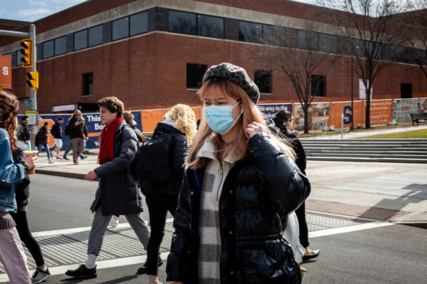 A woman wears a mask at Syracuse University, New York, U.S., March 12, 2020. REUTERS/Maranie Staab