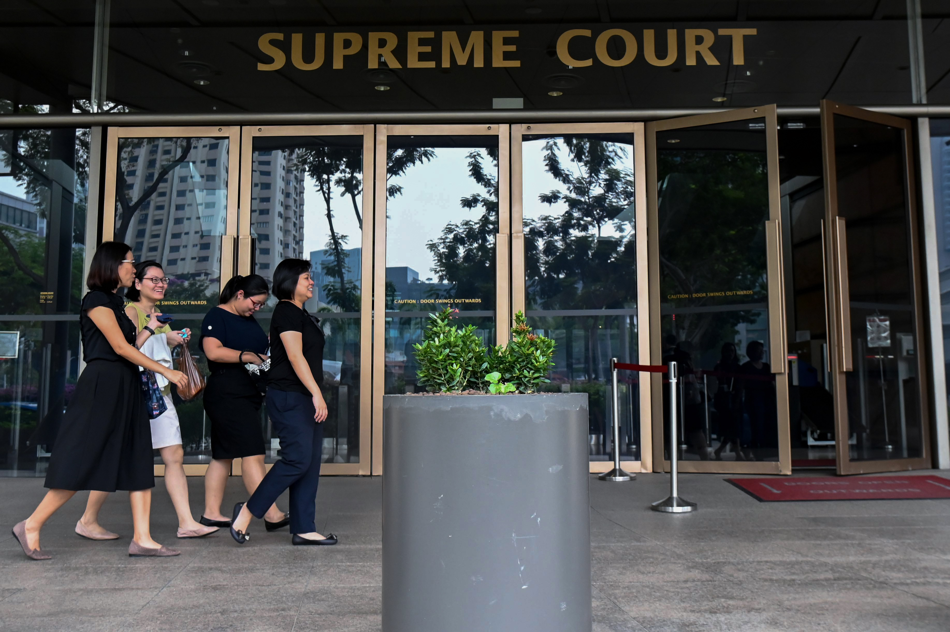 People walk past the Supreme Court entrance in Singapore on November 13, 2019. - A Singaporean court on November 13 began hearing new challenges against a law banning sex between men, the latest bid to overturn the statute and score another victory for rights in Asia. (Photo by Roslan RAHMAN / AFP) (Photo by ROSLAN RAHMAN/AFP via Getty Images)