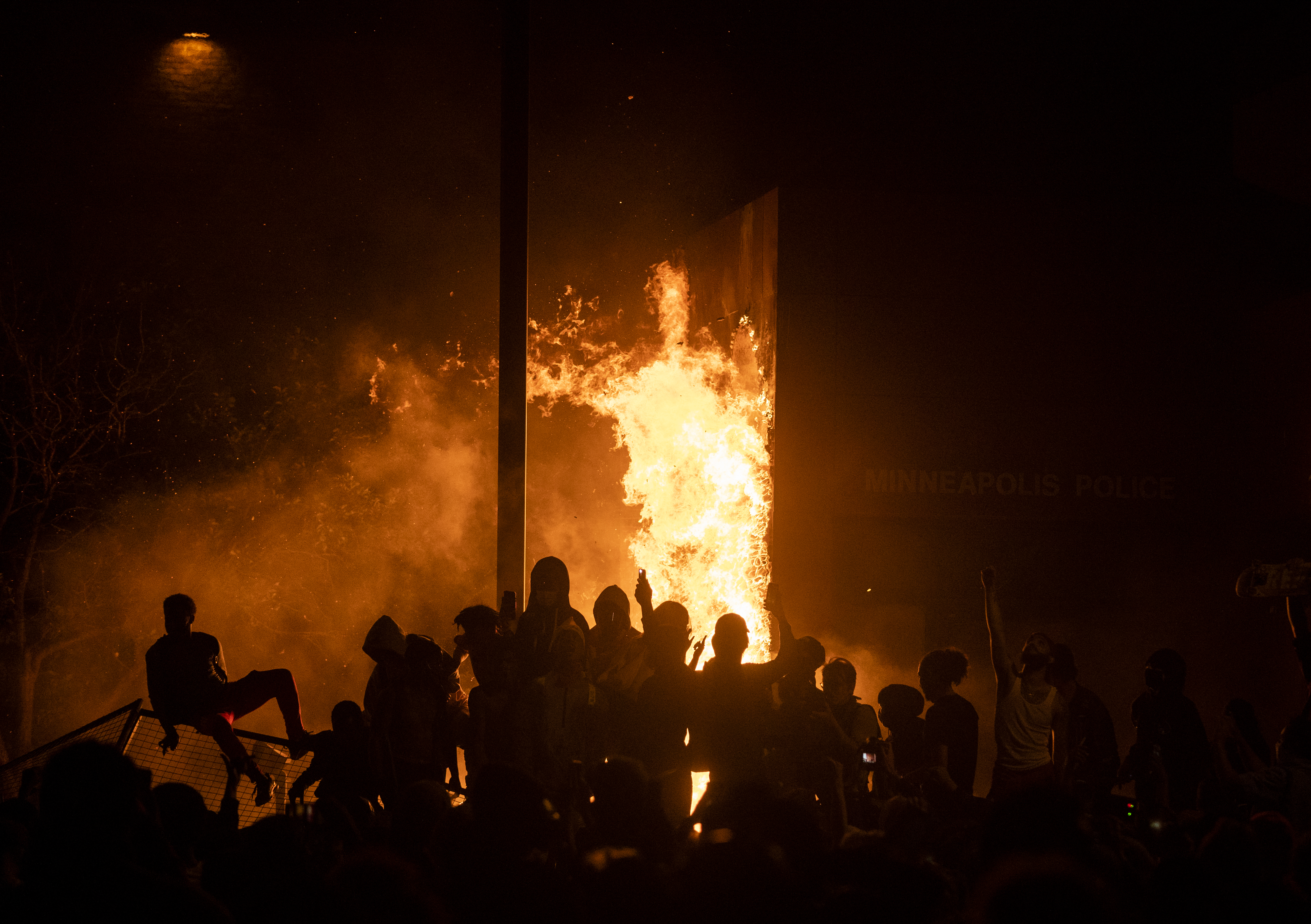 MINNEAPOLIS, MN - MAY 28: Protesters cheer as the Third Police Precinct burns behind them on May 28, 2020 in Minneapolis, Minnesota. As unrest continues after the death of George Floyd police abandoned the precinct building, allowing protesters to set fire to it. (Photo by Stephen Maturen/Getty Images)