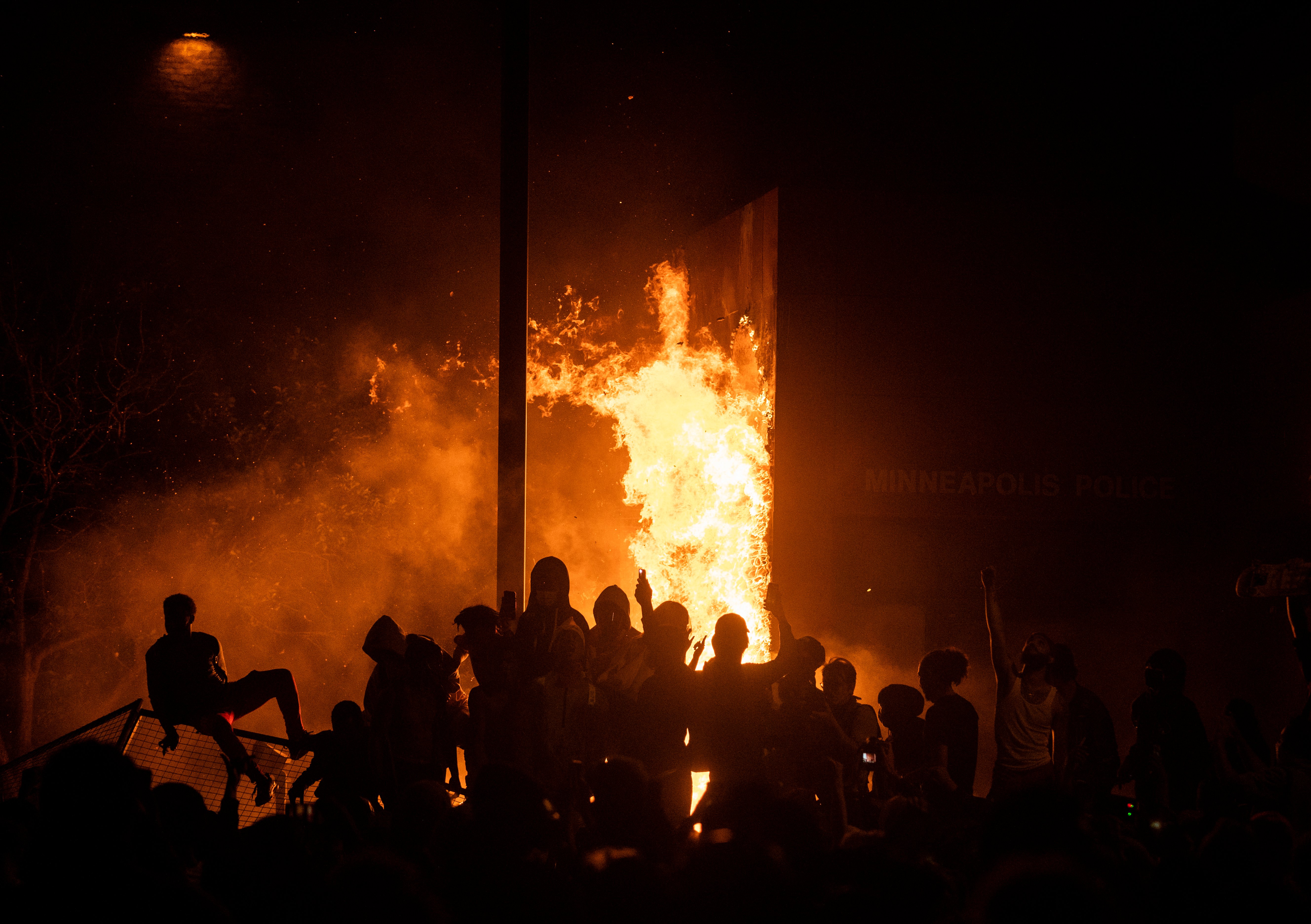 MINNEAPOLIS, MN - MAY 28: Protesters cheer as the Third Police Precinct burns behind them on May 28, 2020 in Minneapolis, Minnesota. As unrest continues after the death of George Floyd police abandoned the precinct building, allowing protesters to set fire to it. (Photo by Stephen Maturen/Getty Images)