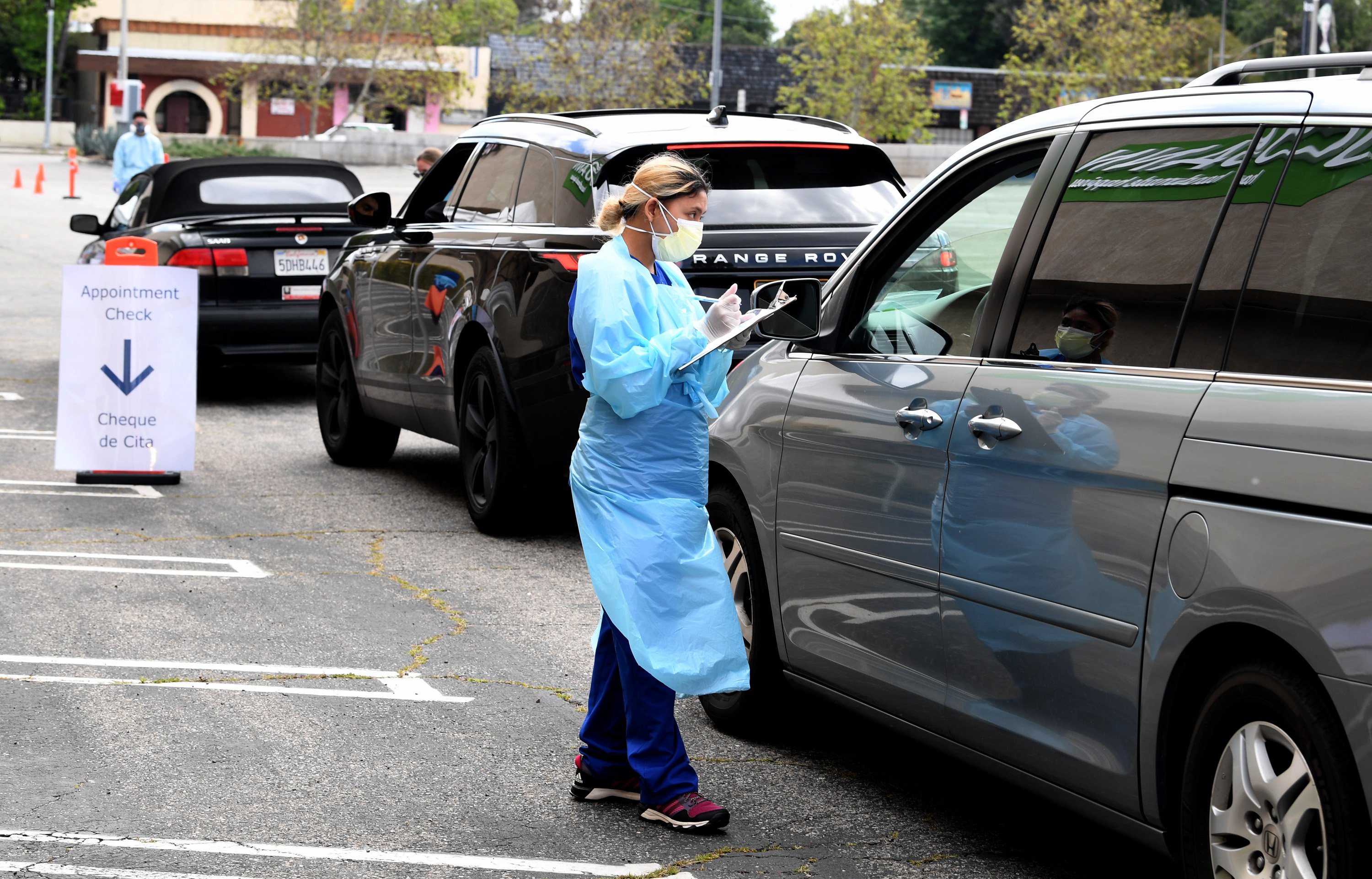 LOS ANGELES, CA - APRIL 13: A worker wearing personal protective equipment gathers the tests administered from a car as Mend Urgent Care hosts a drive-thru testing for the COVID-19 virus at the Westfield Fashion Square on April 13, 2020 in the Sherman Oaks neighborhood of Los Angeles, California. Los Angeles County 'safer at home' orders remain in effect through May 15 to stop the spread of coronavirus during the worldwide pandemic. (Photo by Kevin Winter/Getty Images)