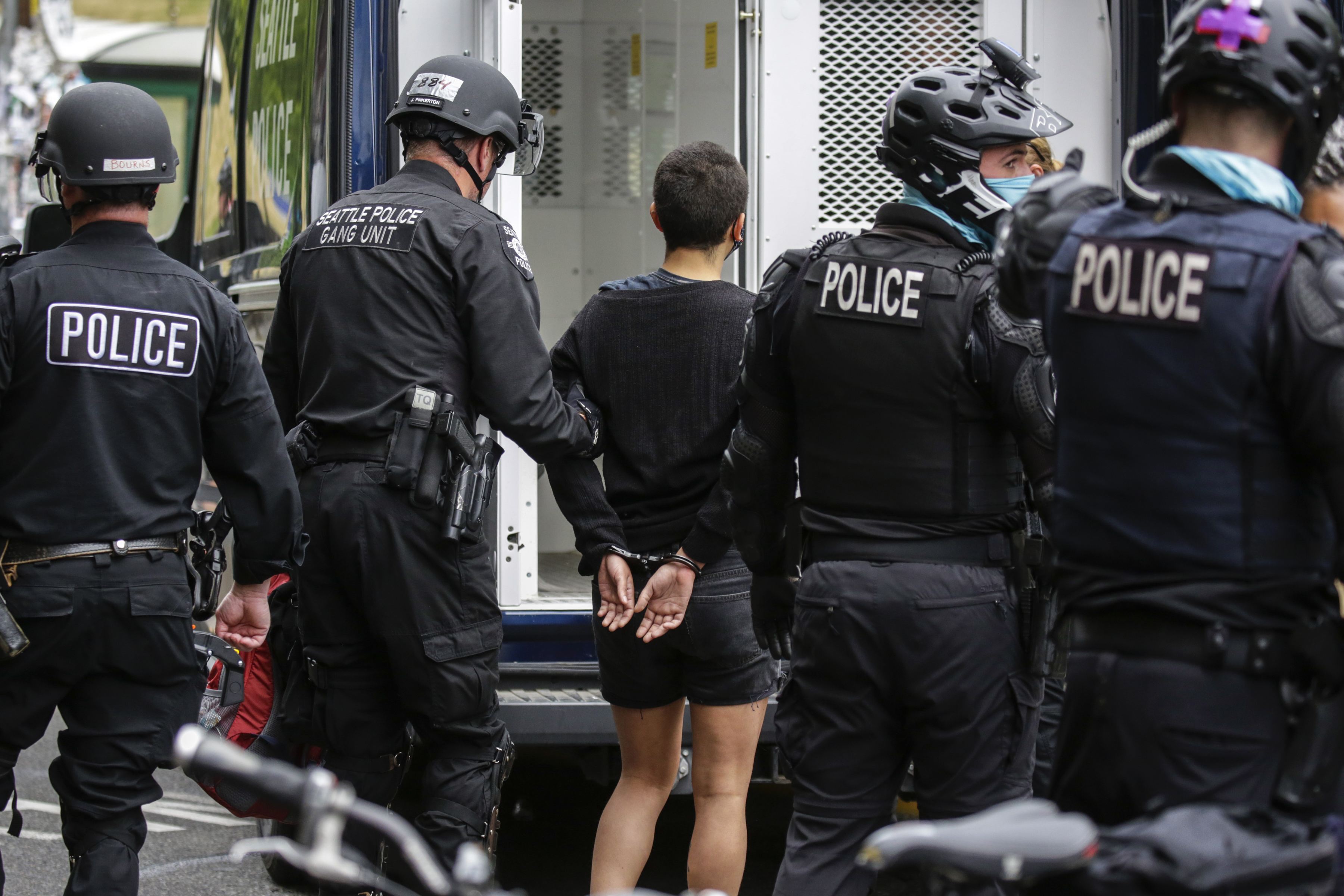 Seattle Police arrest a woman after demonstrators blocked the intersection of East Pine Street and 11th Avenue following the clearing of the Capitol Hill Occupied Protest (CHOP) by police in Seattle, Washington on July 1, 2020. (JASON REDMOND/AFP via Getty Images)