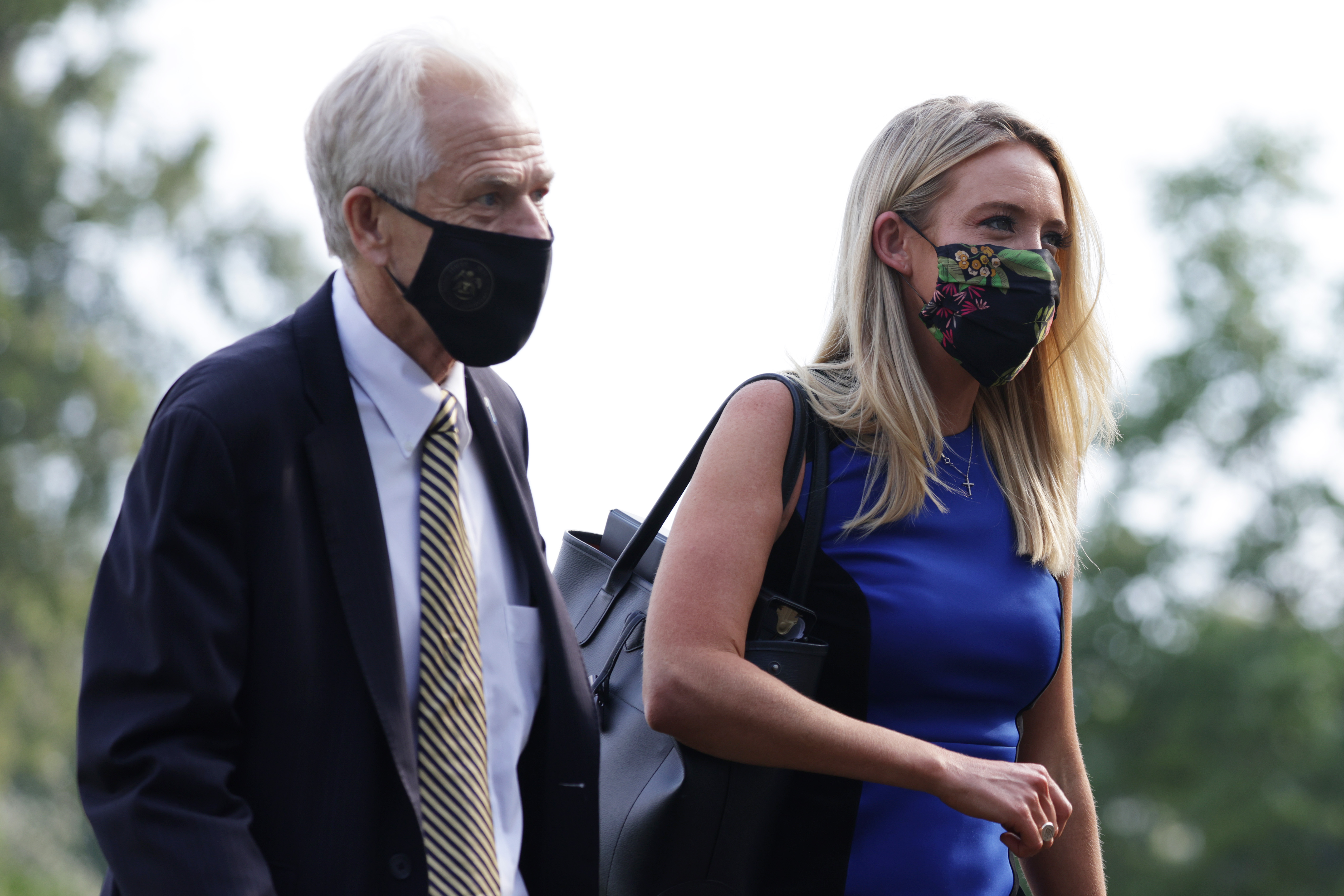 WASHINGTON, DC - JULY 27: White House Trade Adviser Peter Navarro and White House Press Secretary Kayleigh McEnany walk on the South Lawn after landing aboard Marine One at the White House from a trip with President Donald Trump July 27, 2020 in Washington, DC. Trump was returning from a visit to the FUJIFILM Diosynth Biotechnologies' Innovation Center in Morrisville, North Carolina, a facility that supports manufacturing of "key components of the COVID-19 vaccine candidate" developed by Novavax. (Photo by Alex Wong/Getty Images)
