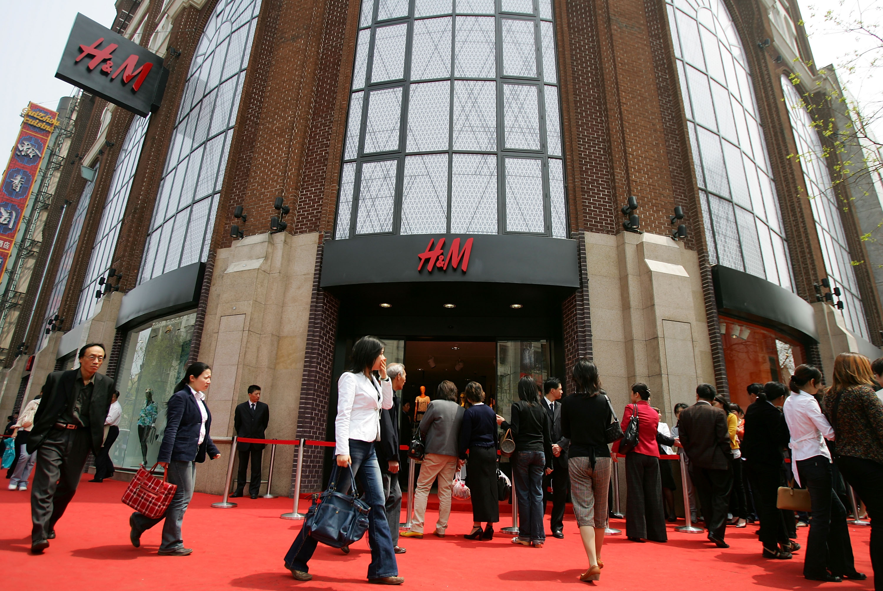 Chinese shoppers wait in line to enter the newly opened H&M store, the first in mainland China, on April 13, 2007 in Shanghai, China. Australian pop singer Kylie Minogue attended the launch. (Photo by Cancan Chu/Getty Images)