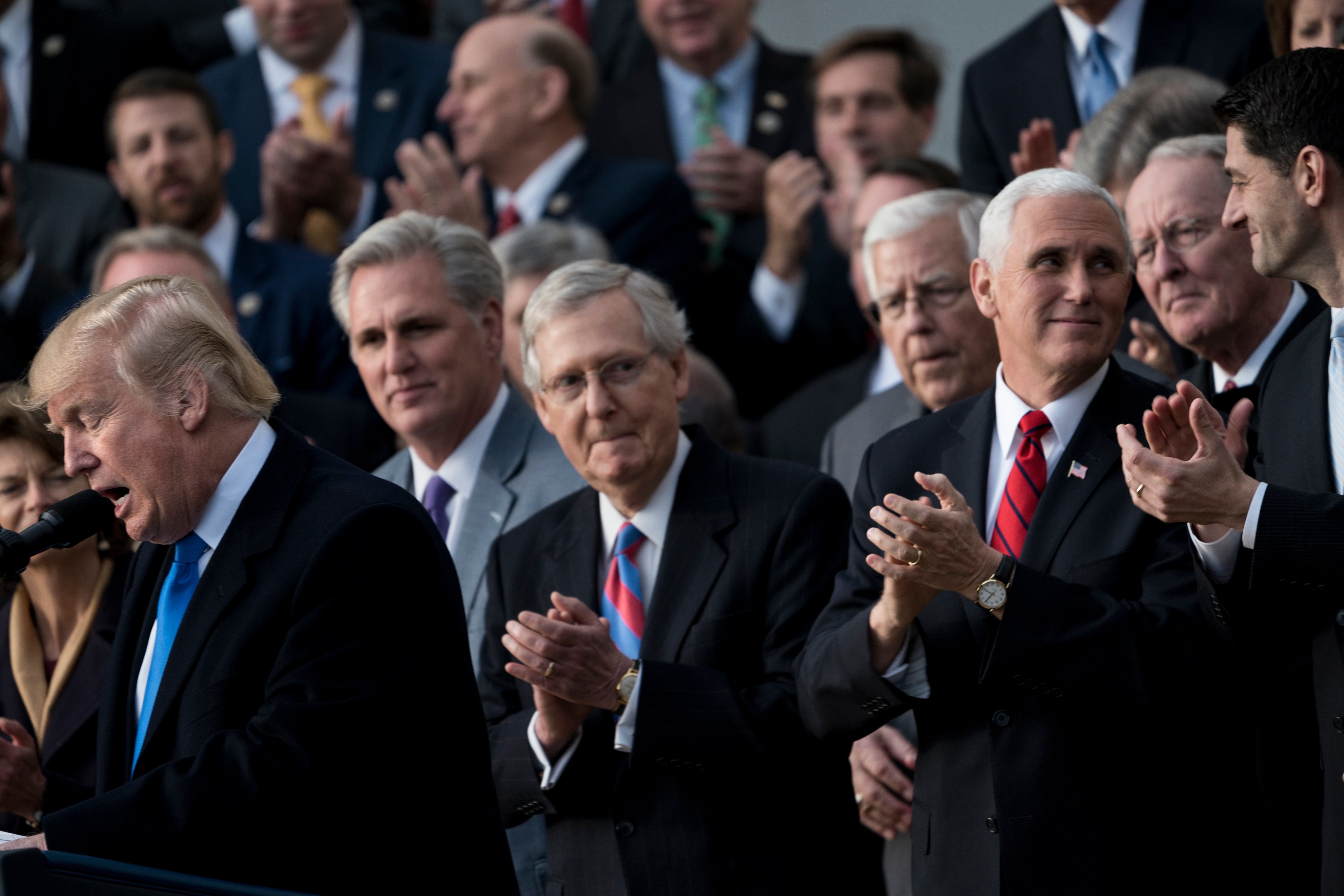 House Majority Leader Representative Kevin McCarthy (R-CA) (2L), Senate Majority Leader Senator Mitch McConnell (R-KY) (C), US Vice President Mike Pence (2R), Speaker of the House Paul Ryan (R-WI) (R) and others listen while US President Donald Trump speaks about newly passed tax reform legislation during an event December 20, 2017 in Washington, DC. Trump hailed a "historic" victory Wednesday as the US Congress passed a massive Republican tax cut plan, handing the president his first major legislative achievement since taking office nearly a year ago. (BRENDAN SMIALOWSKI/AFP via Getty Images)