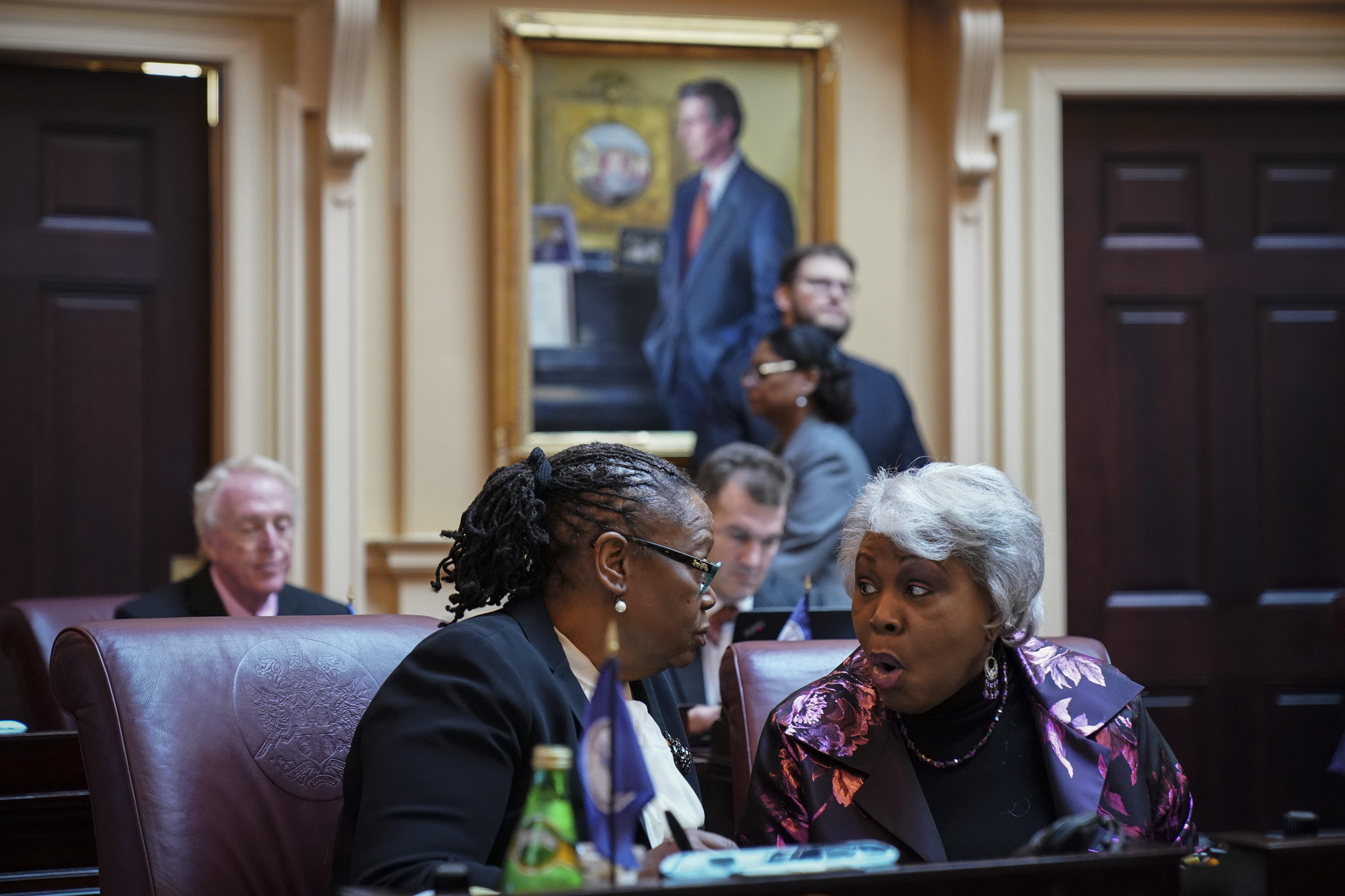 RICHMOND, VA - FEBRUARY 07: (L-R) State Senators Mamie Locke and L. Louise Lucas, both Democrats and members of the Virginia Legislative Black Caucus, speak to each other on the Senate floor at the Virginia State Capitol, February 7, 2019 in Richmond, Virginia. Virginia state politics are in a state of upheaval, with Governor Ralph Northam and State Attorney General Mark Herring both admitting to past uses of blackface and Lt. Governor Justin Fairfax accused of sexual misconduct. (Photo by Drew Angerer/Getty Images)